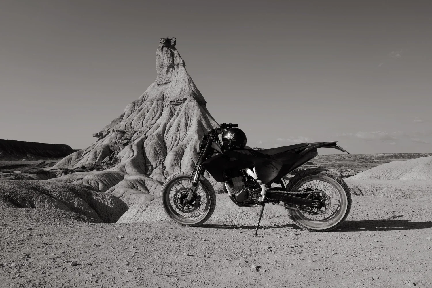 A motorcycle beneath the sculpted rock formations of Bardenas Reales, Spain