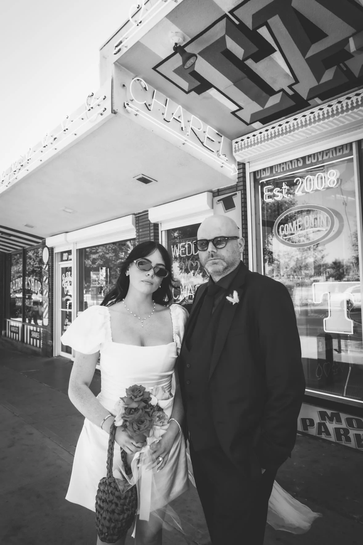 Real Bride wears a bespoke silk wedding dress for her Las Vegas elopement. It is a mini wedding dress with a corseted boned bodice, puff sleeves and lots of draping. Designed & made in Liverpool by high fashion wedding wear designer Emily Butler