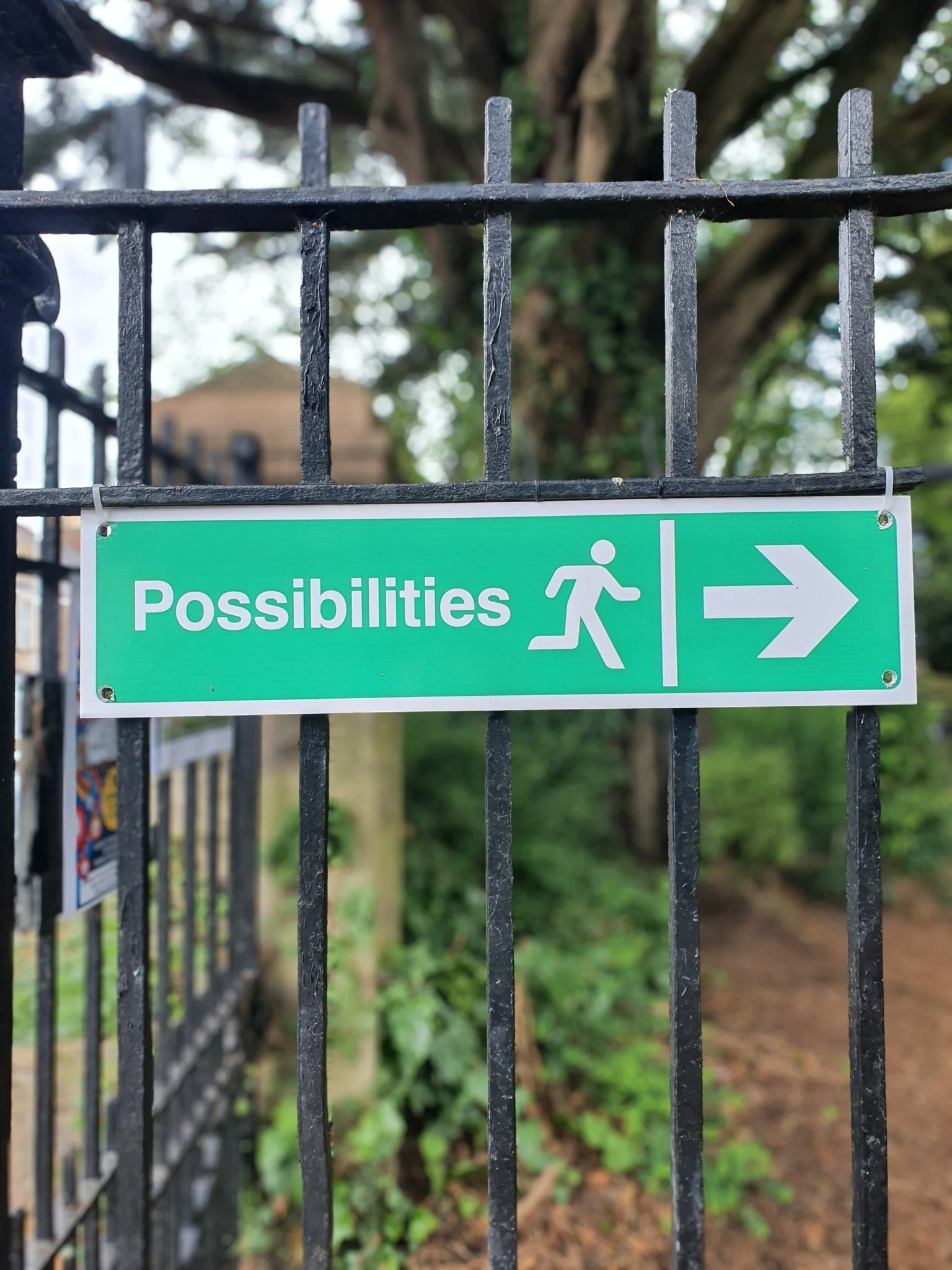 Sign in a park saying 'Possibilities' with a person running icon