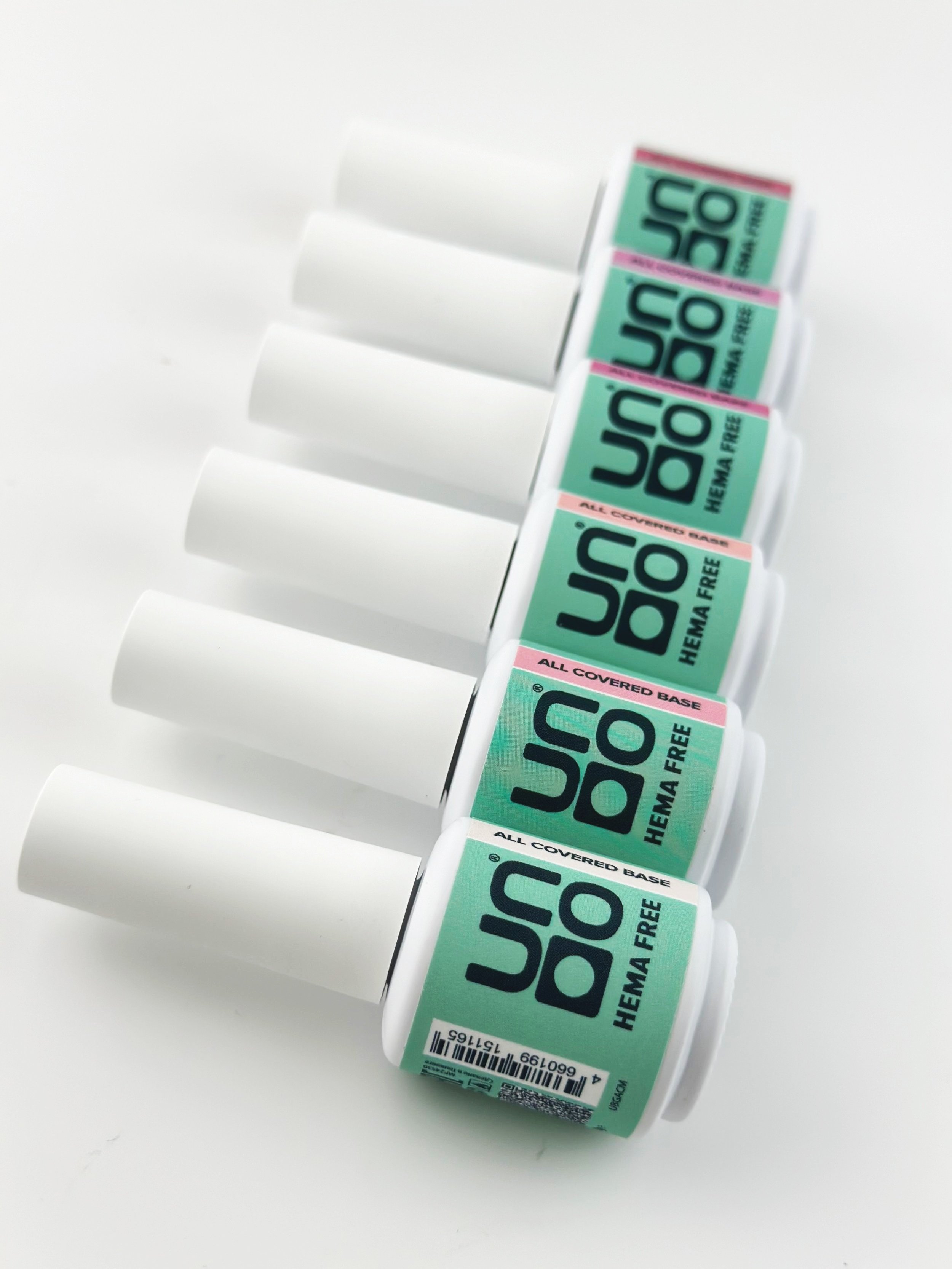 A row of six bottles of U.S. Soak hema-free, all-covered base nail polish, with the bottles turned on their side, displaying the labels.