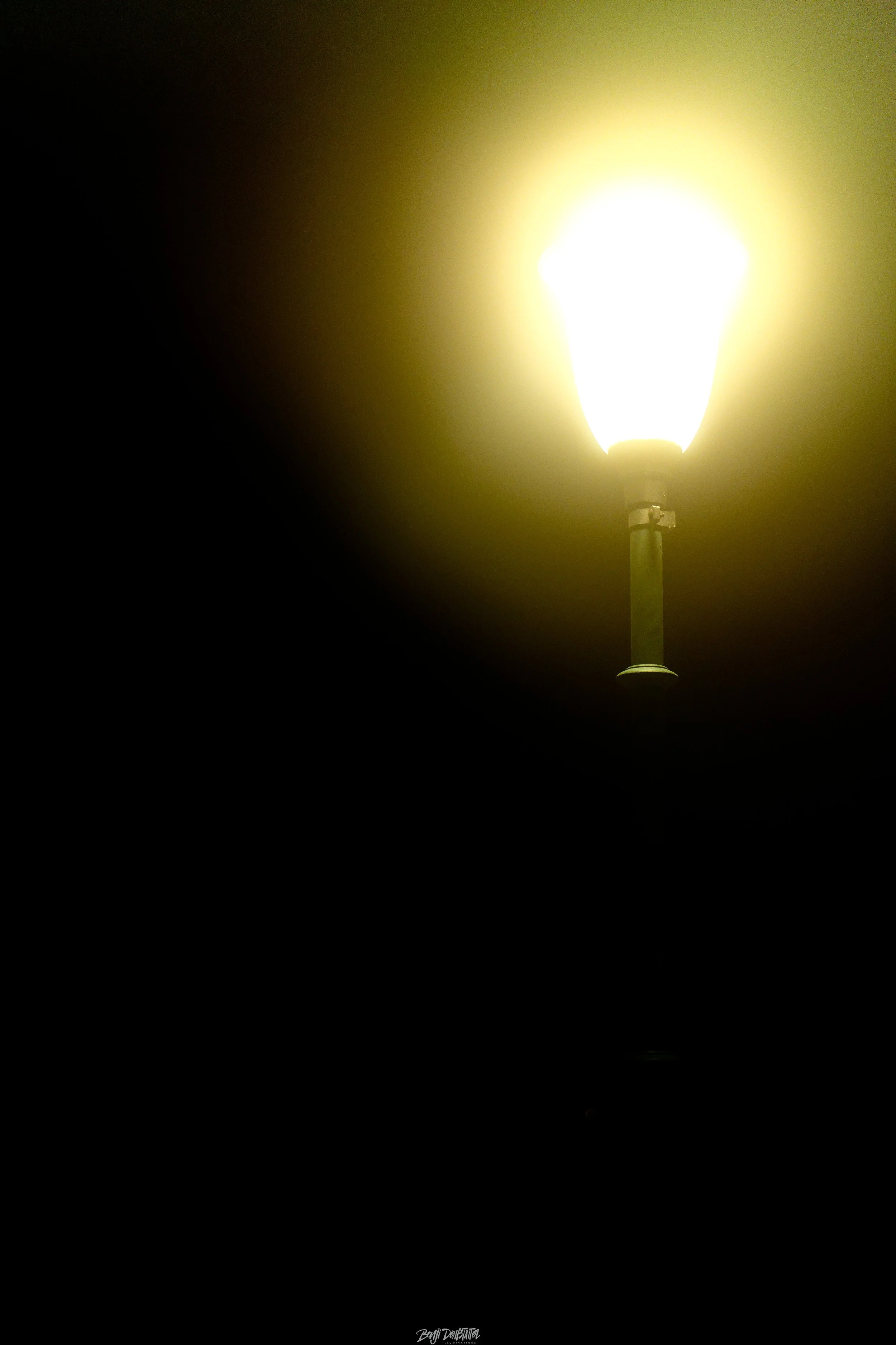 A bright streetlamp illuminating the darkness with a glow.