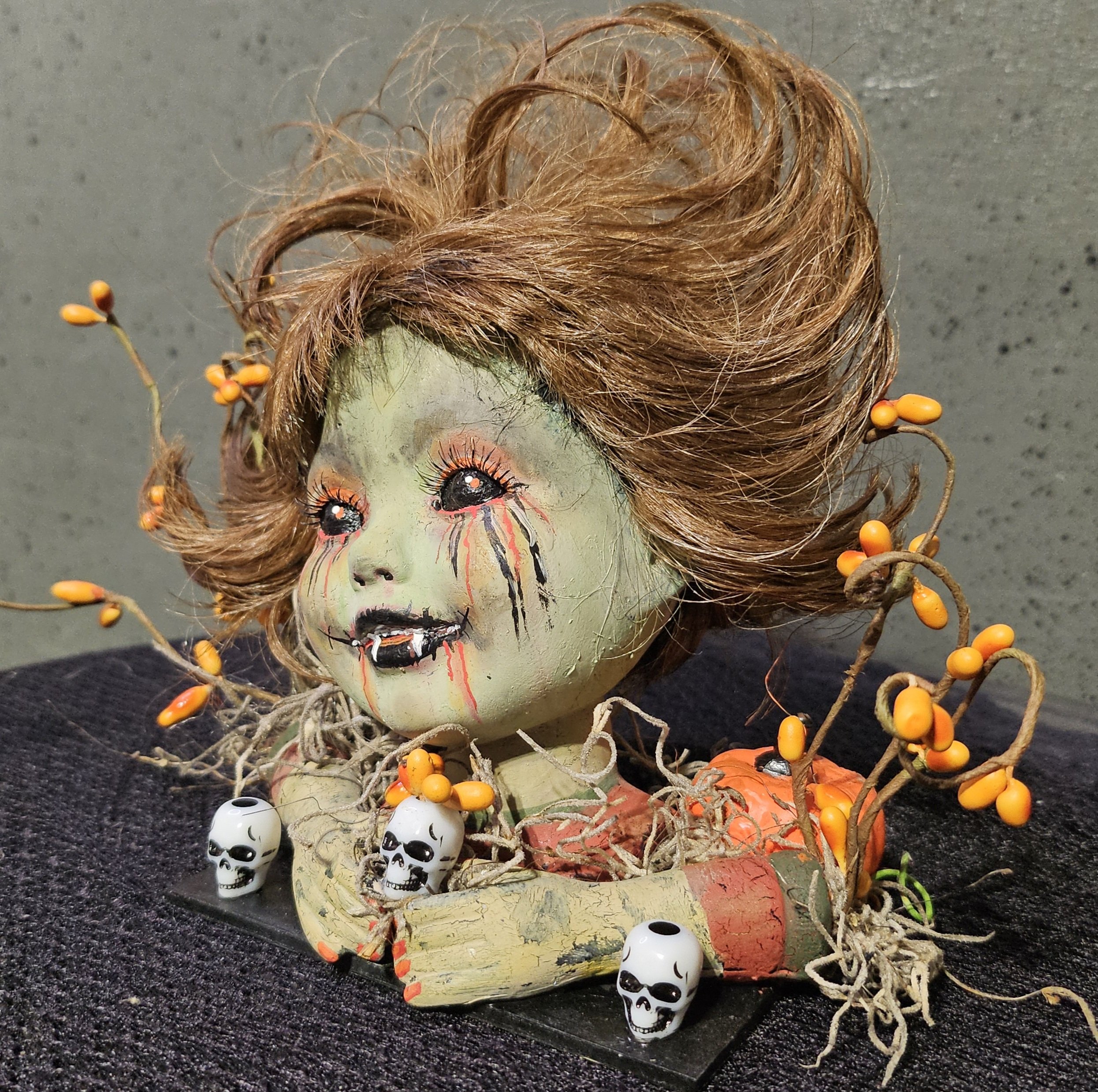  Left-side view of Autumn Bite, a handmade vampire doll with wild brown hair, tiny fangs, blood-streaked tears, skulls, pumpkins, and twisted branches. 