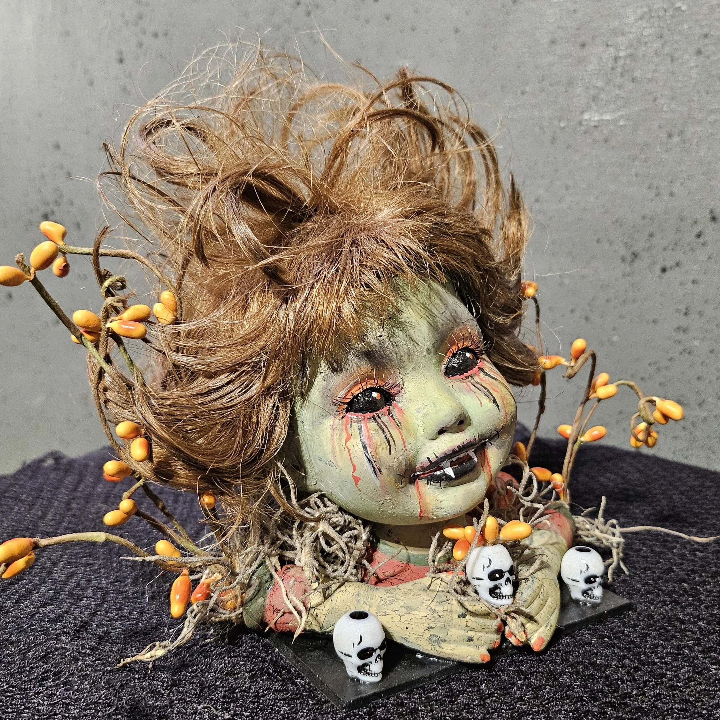  Right-side view of Autumn Bite showing her small vampire fangs, painted blood tears, tangled hair, miniature skulls, moss, and autumn berries. 