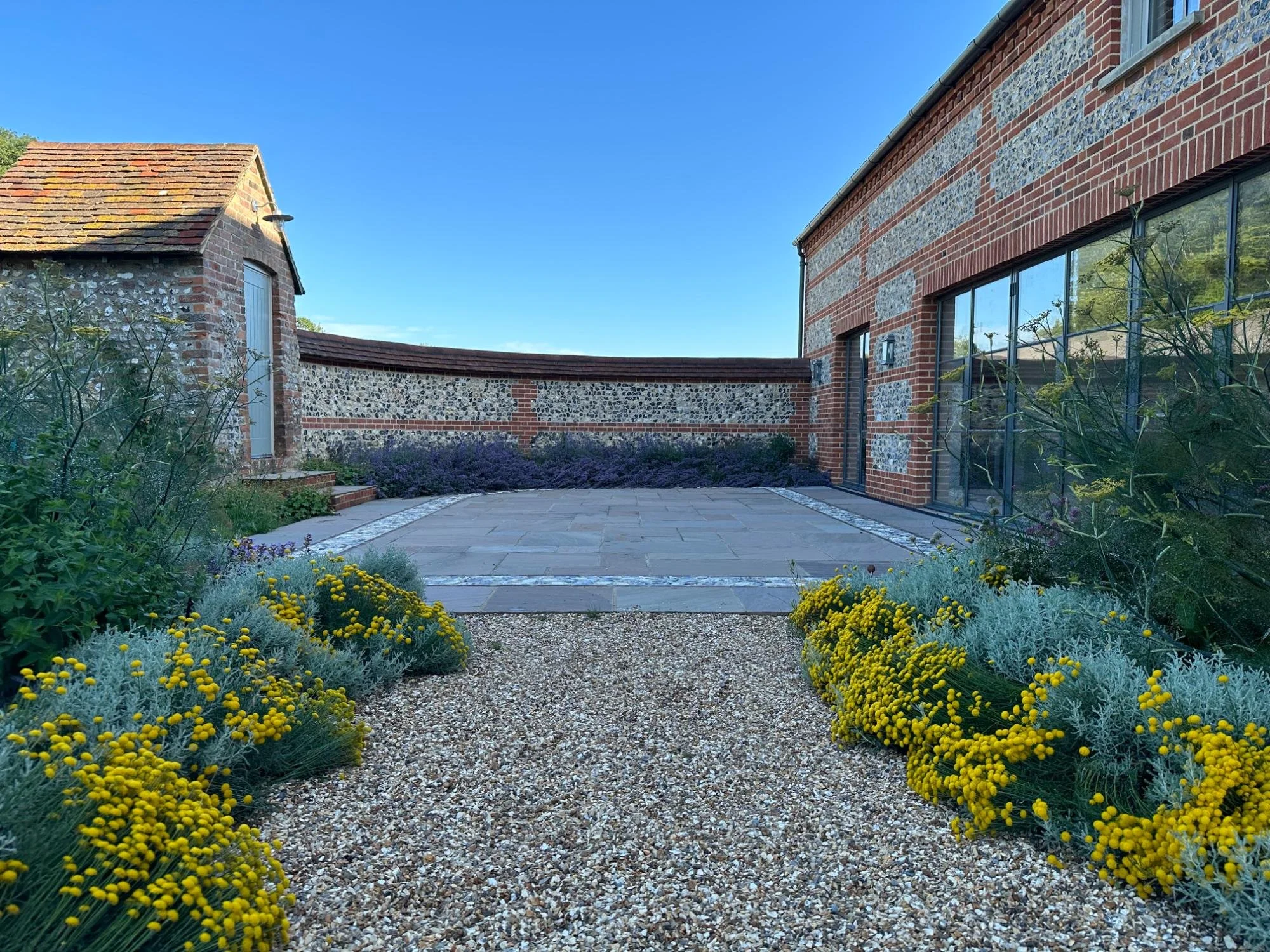The kitchen terrace with its brick and flint wall