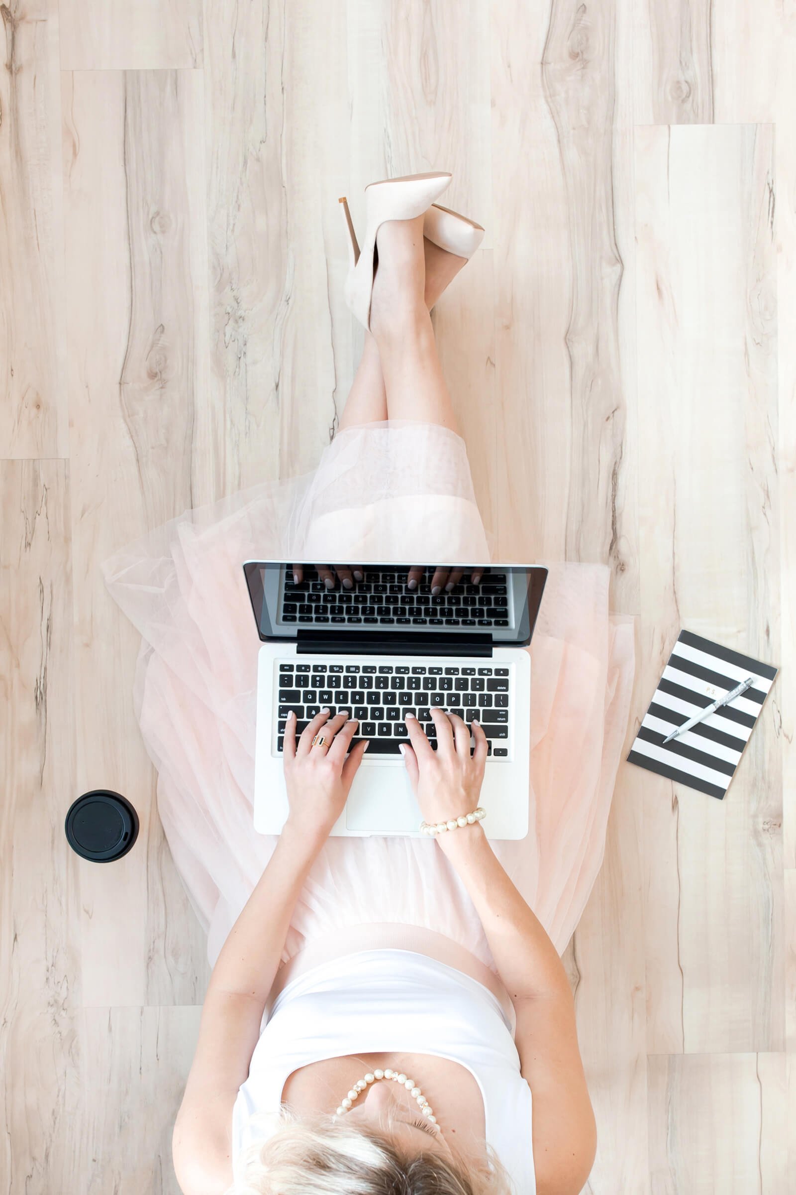 An image of a woman, sitting and searching for businesses on a laptop