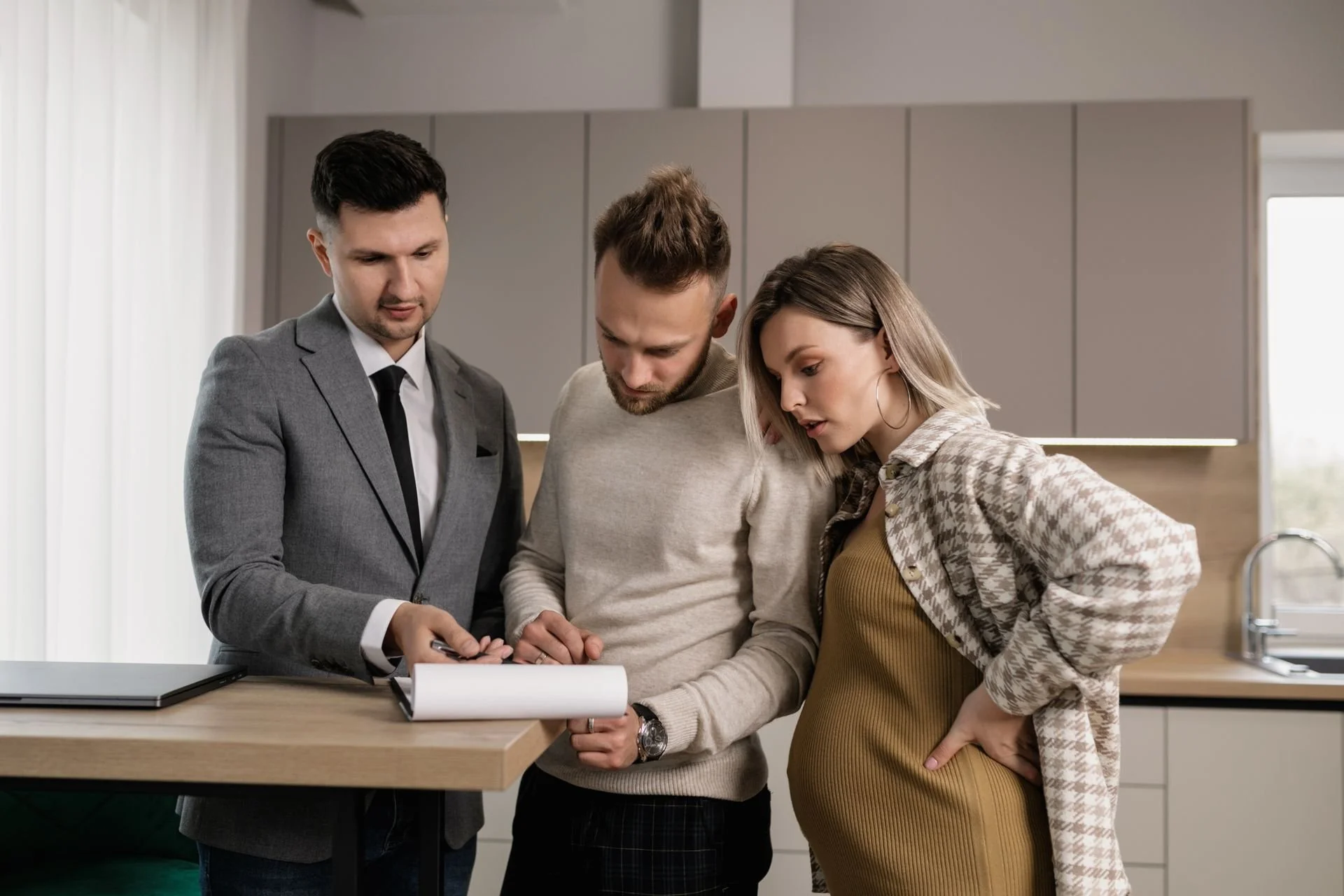 three workers looking at paper, one pregnant