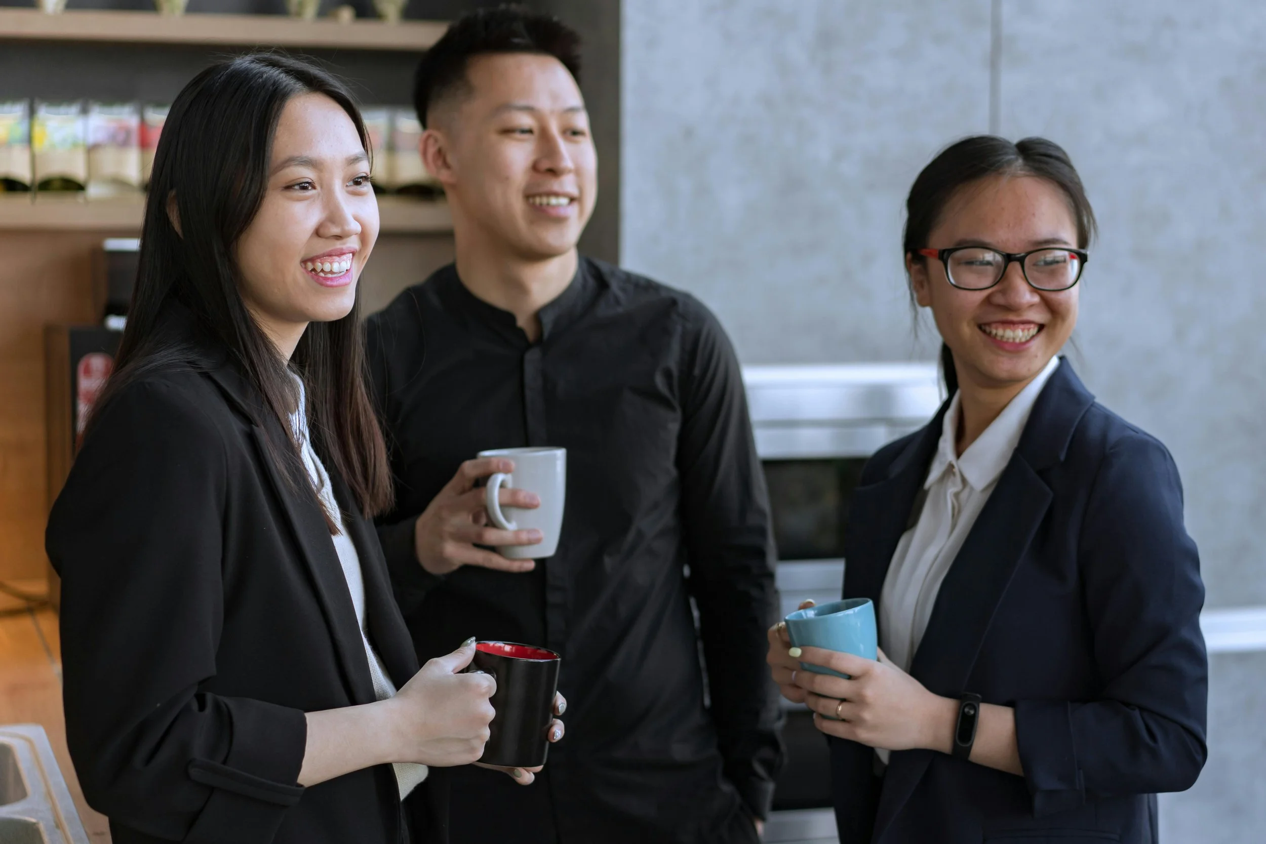 colleagues chatting holding coffee mugs