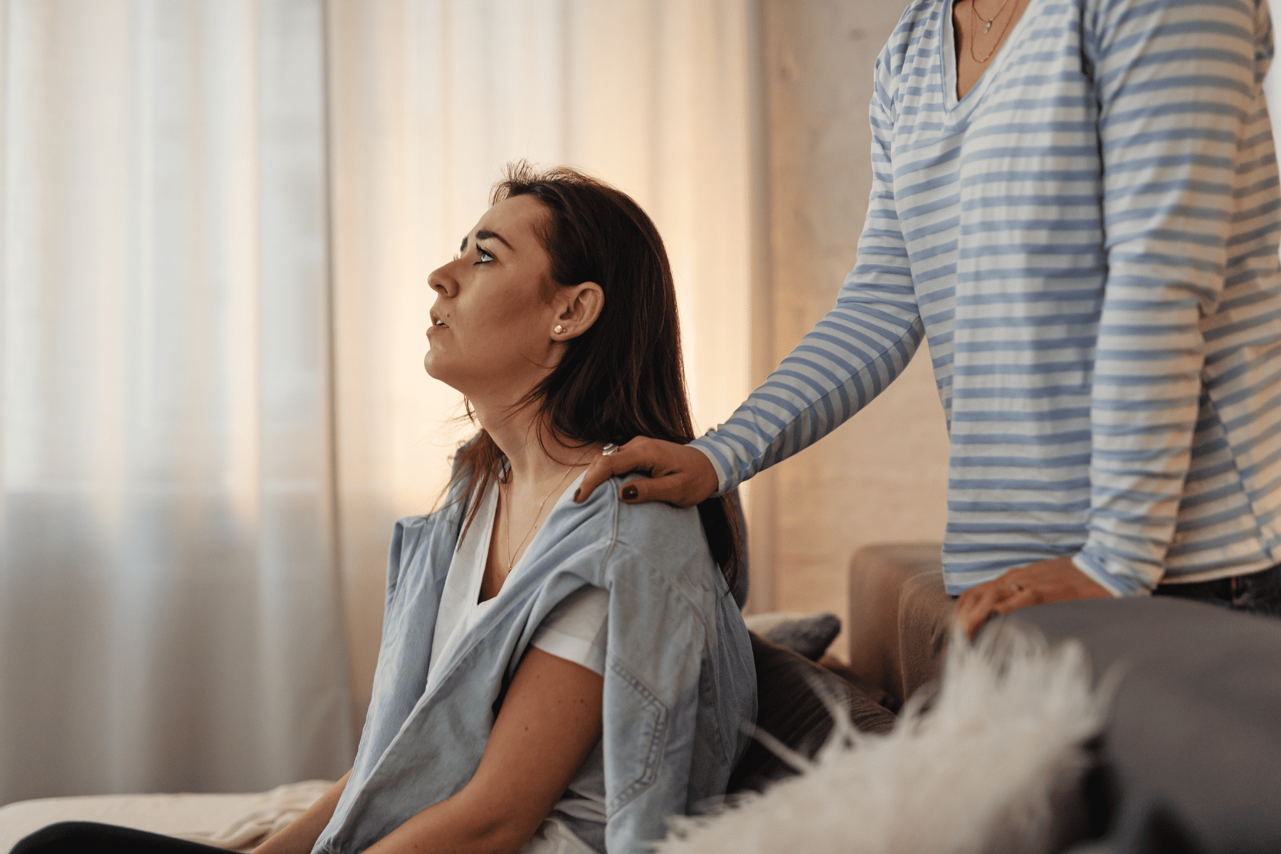 Άνθρωπος ακουμπά απαλά τον ώμο γυναίκας σε πένθος, προσφέροντας σιωπηλή στήριξη