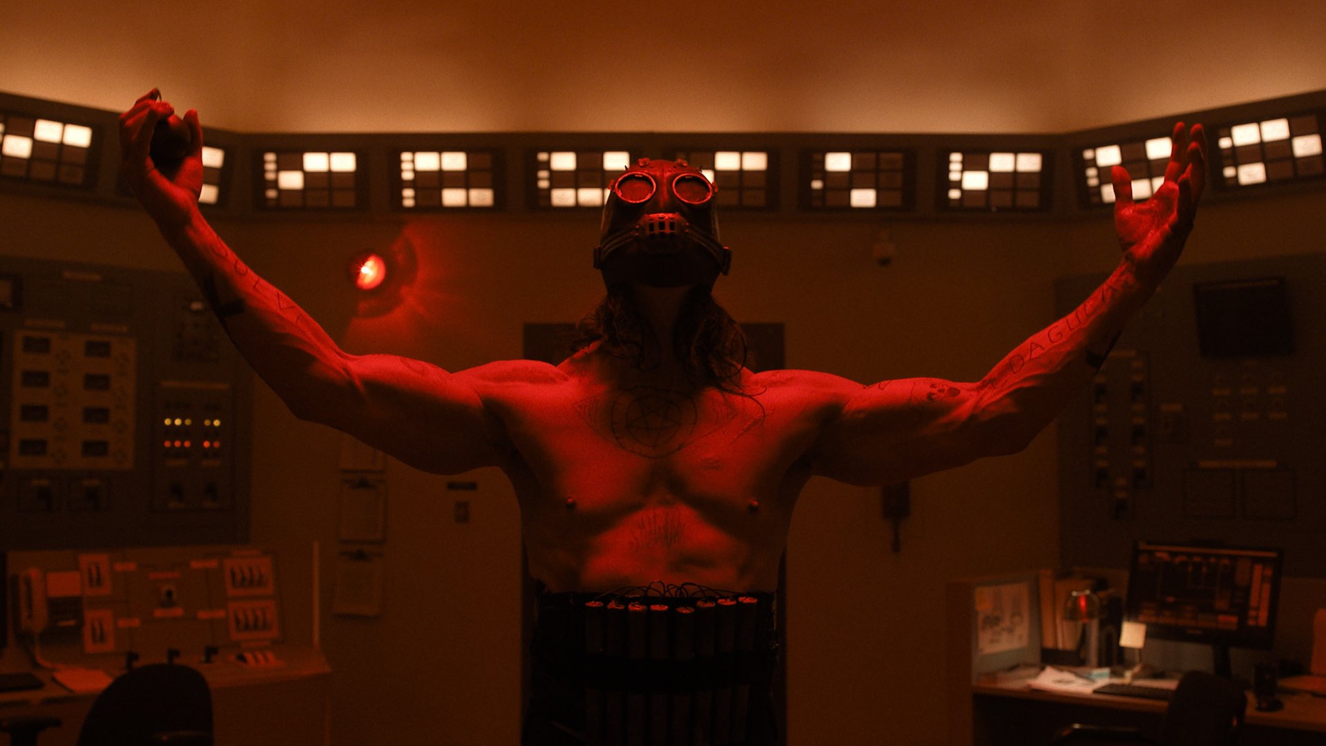 The masked killer from Psycho Killer. He's shirtless with his arms raised in a worshipful stance. The scene is bathed in red light and he's wearing a belt of dynamite.