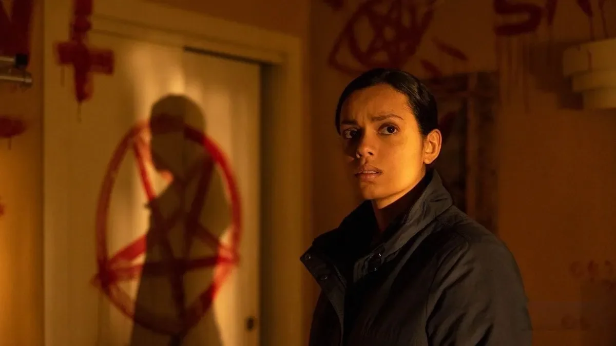 Gerogina Campbell in the film Psycho Killer. There are satanic symbols (inverted cross, pentagram, and other) painted in blood on the wall.