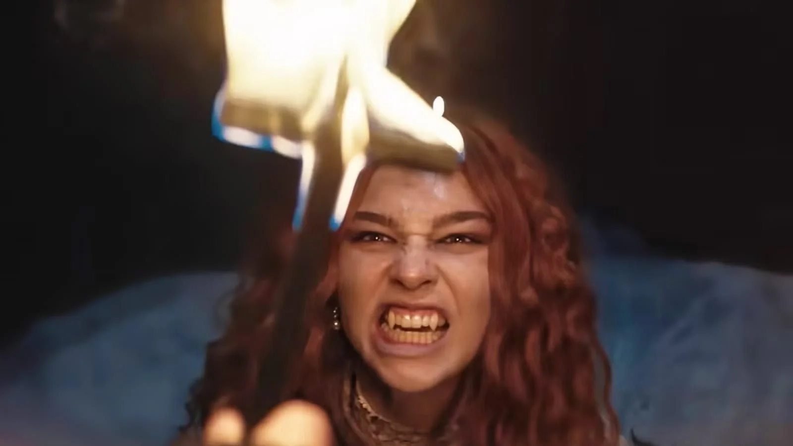 Matilda De Angelis with a flaming cross held in front of her face.
