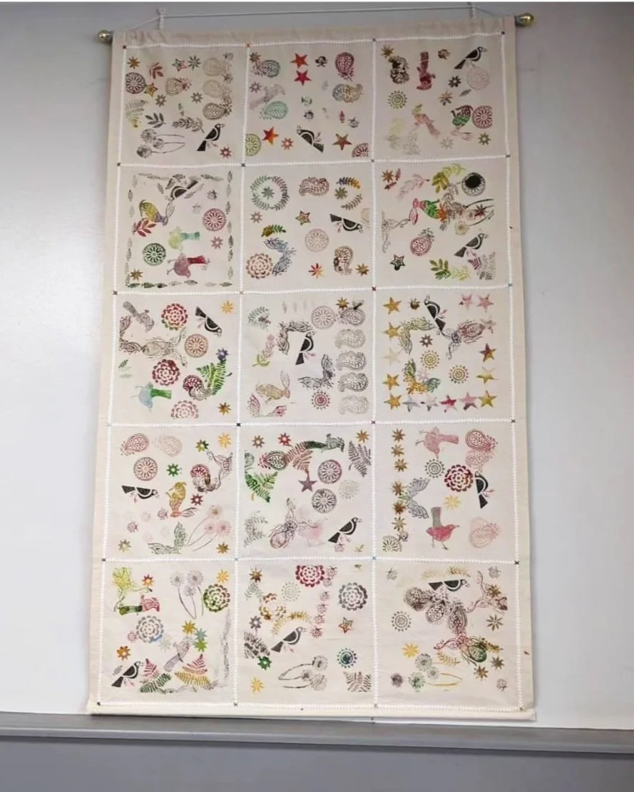 Detail image of grid of block printed fabic with various nature based symbols