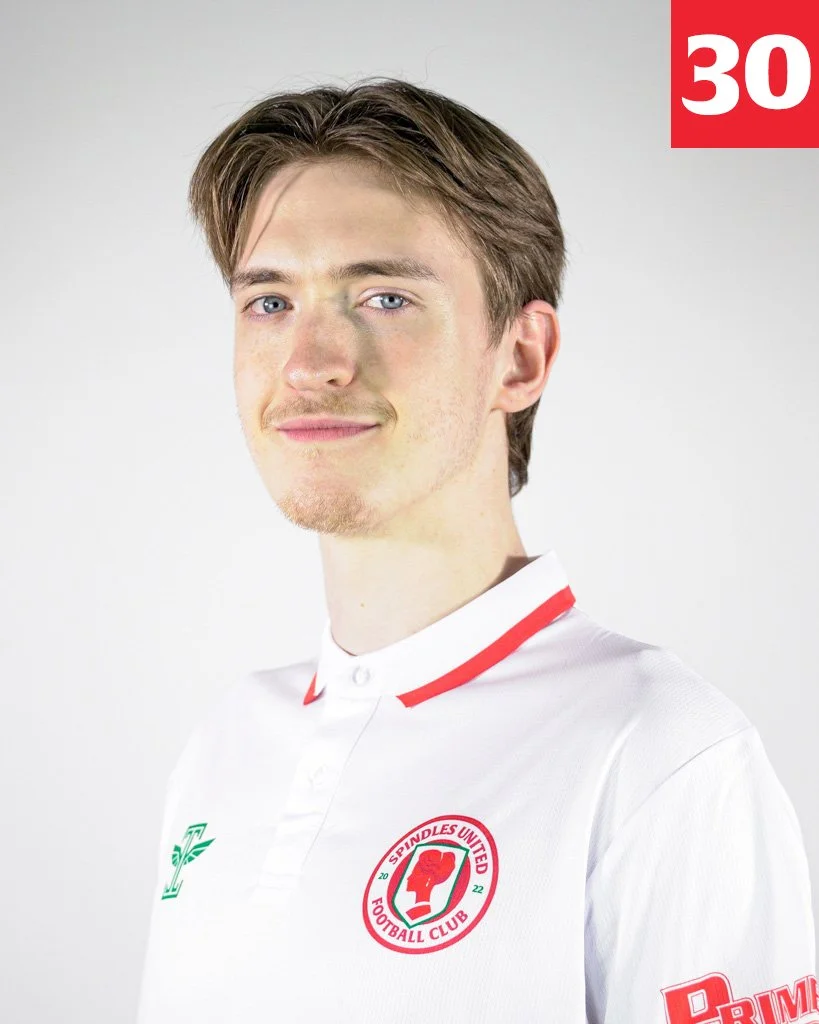 Young man wearing a white football jersey with red accents and the Spindles United Football Club logo, posing for a portrait against a plain white background.