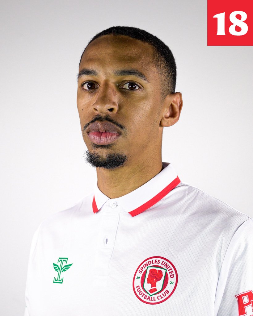 Portrait of a soccer player wearing a white Spindles United Football Club jersey with red accents, against a plain white background.