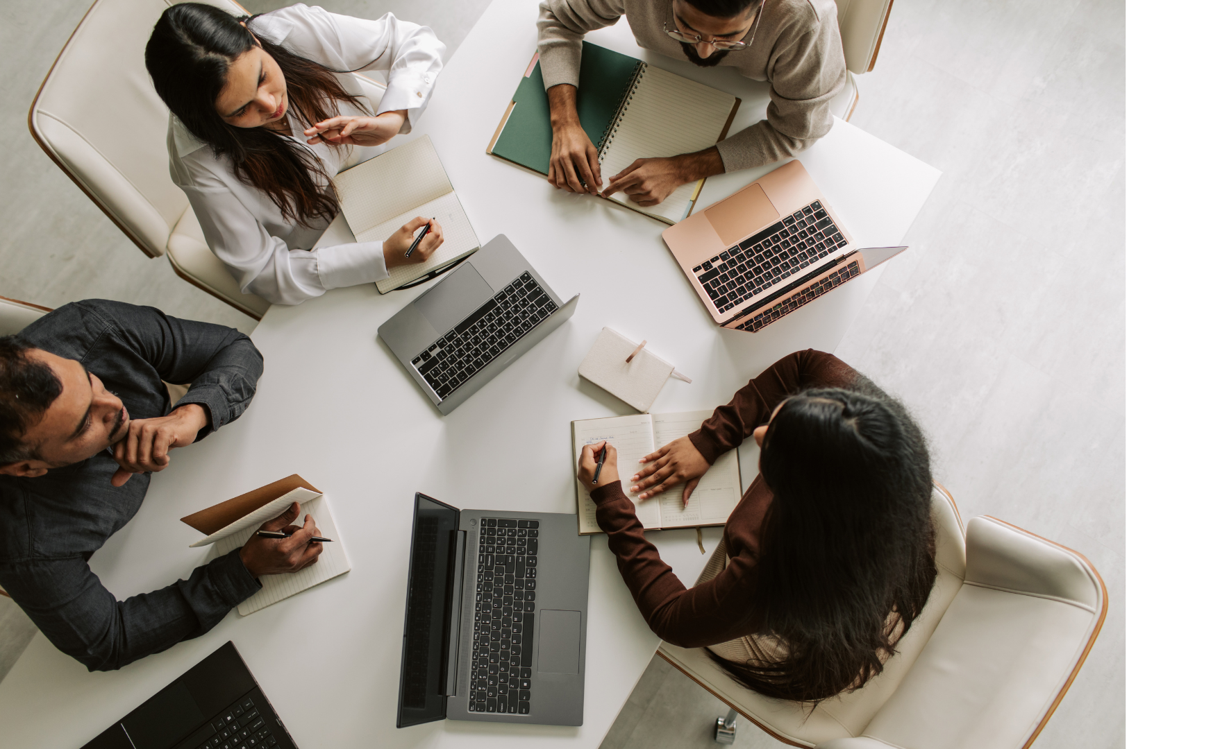 An aerial view of a group of people working at a desk.