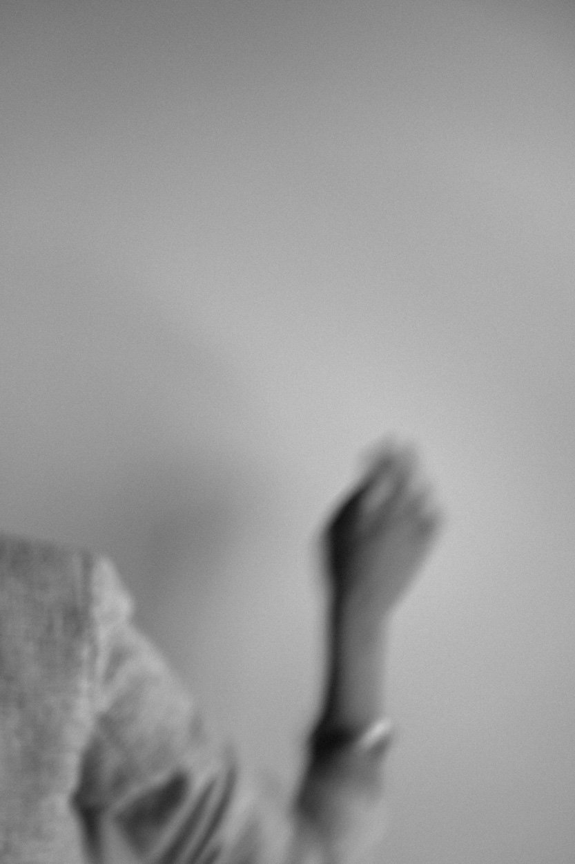 black and white ethereal image of a woman holding up her hand in black and white