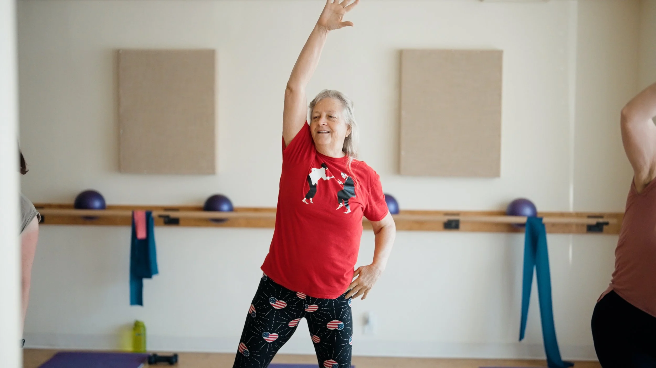 women working out in a black lit fitness studio.