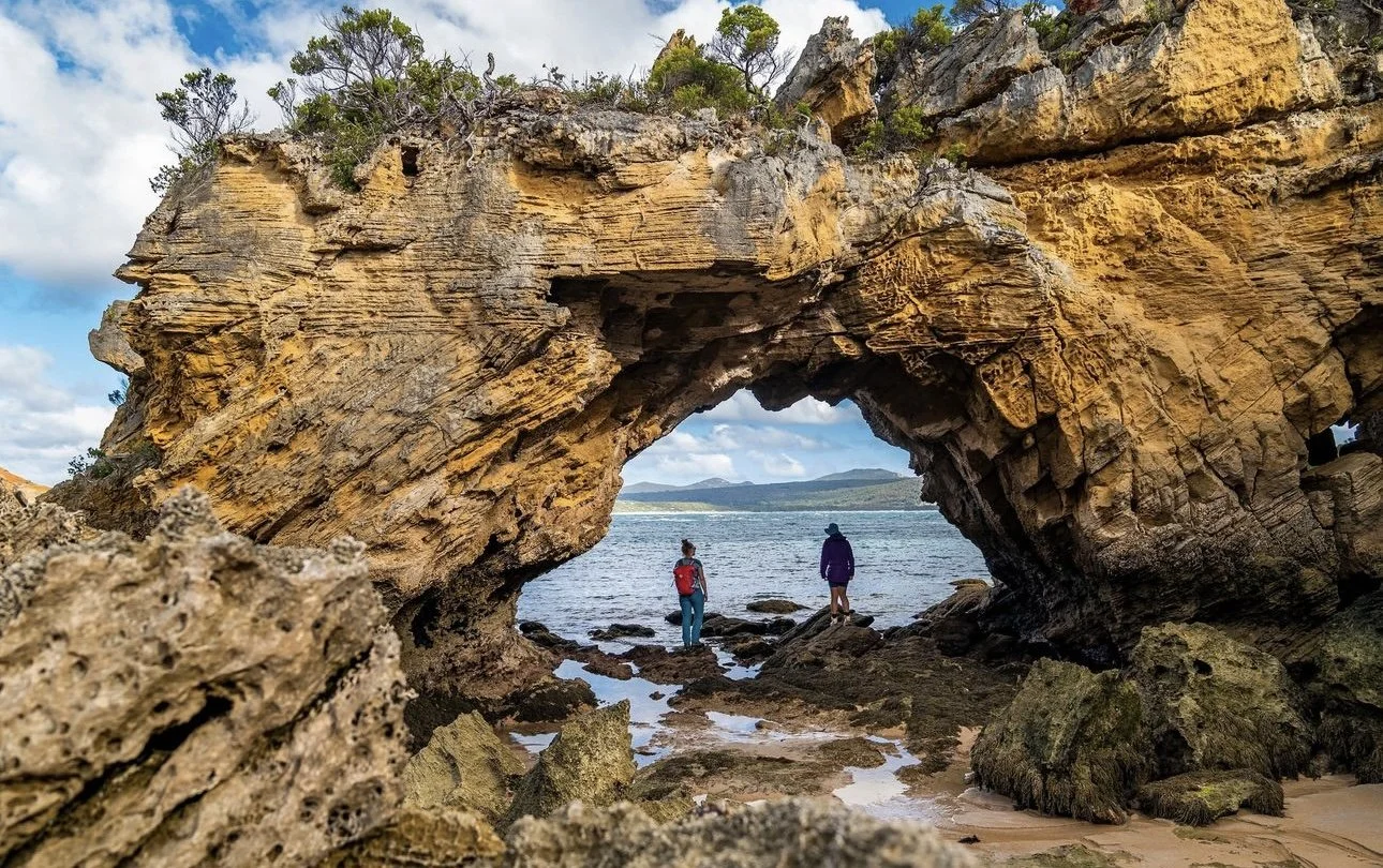 Flights to Flinders Island | Flinders Island Aviation | Pair standing under rock formation