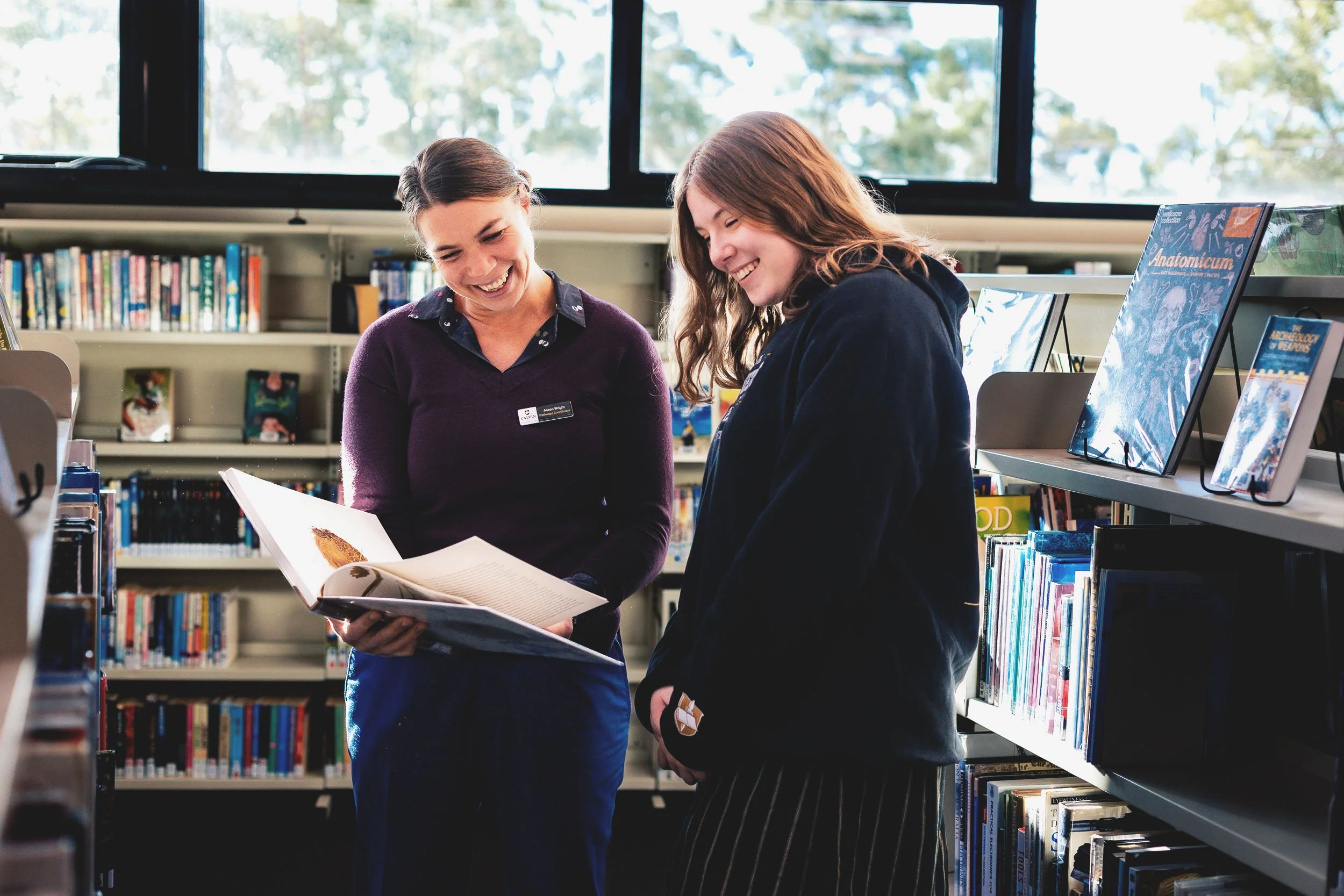 Alison Wright showing a student a book in the classroom