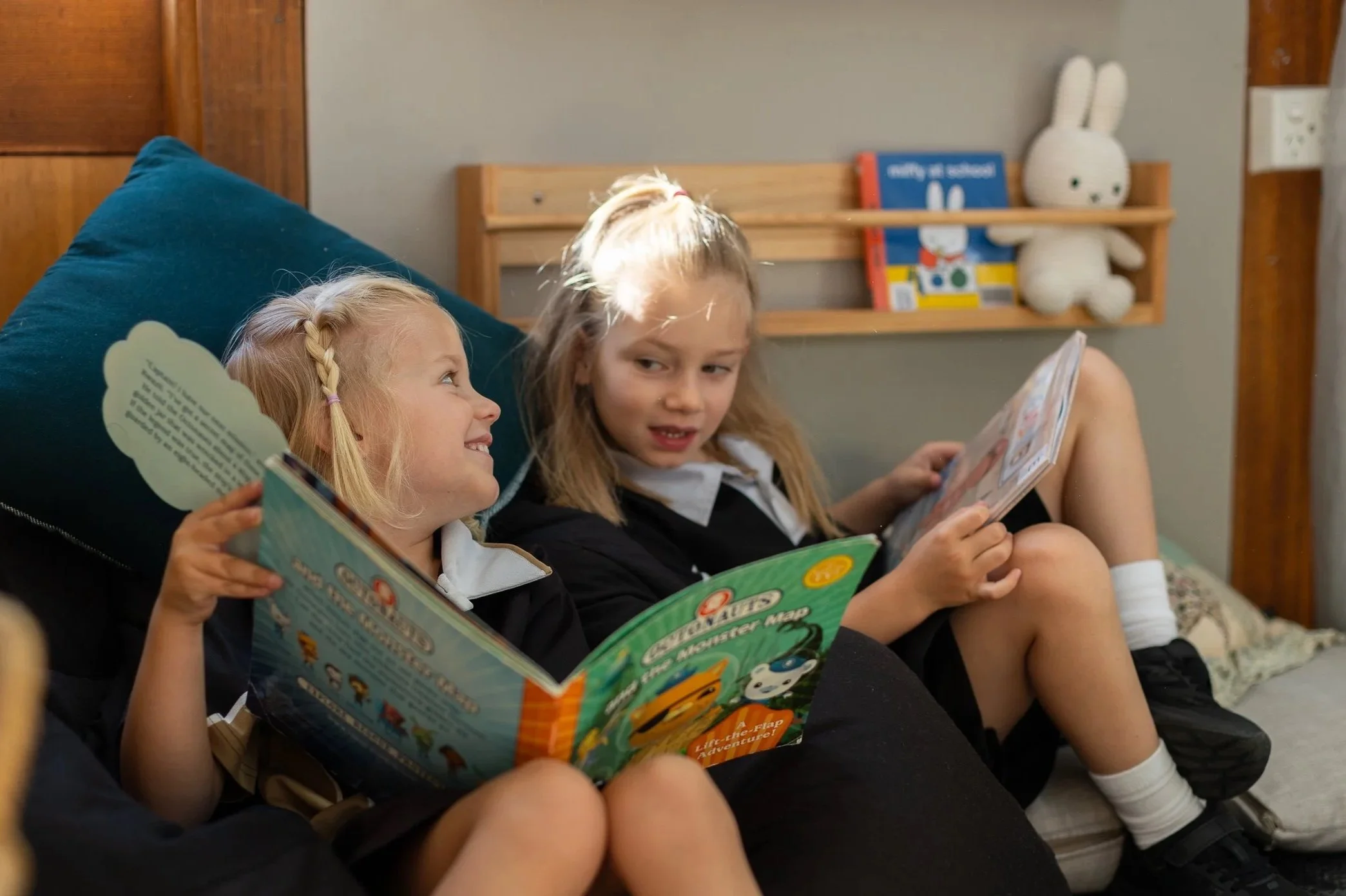 Two young Kindergarten students reading a book and laughing
