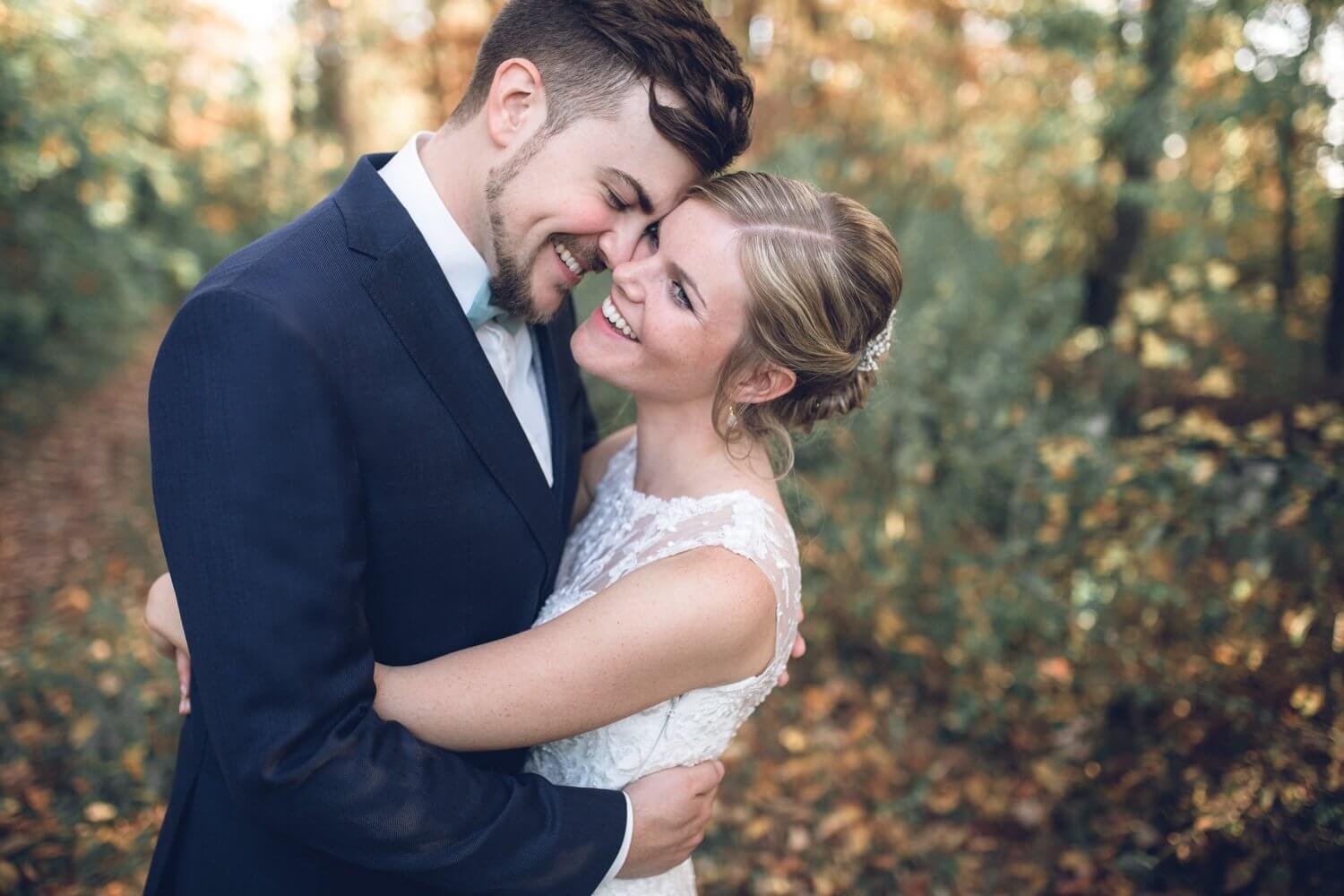 Ein glückliches Hochzeitspaar in inniger Umarmung im Freien.