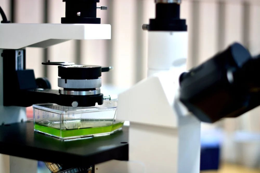 Dette er et mikroskop som er brukt til å studere prøver i et laboratorium.