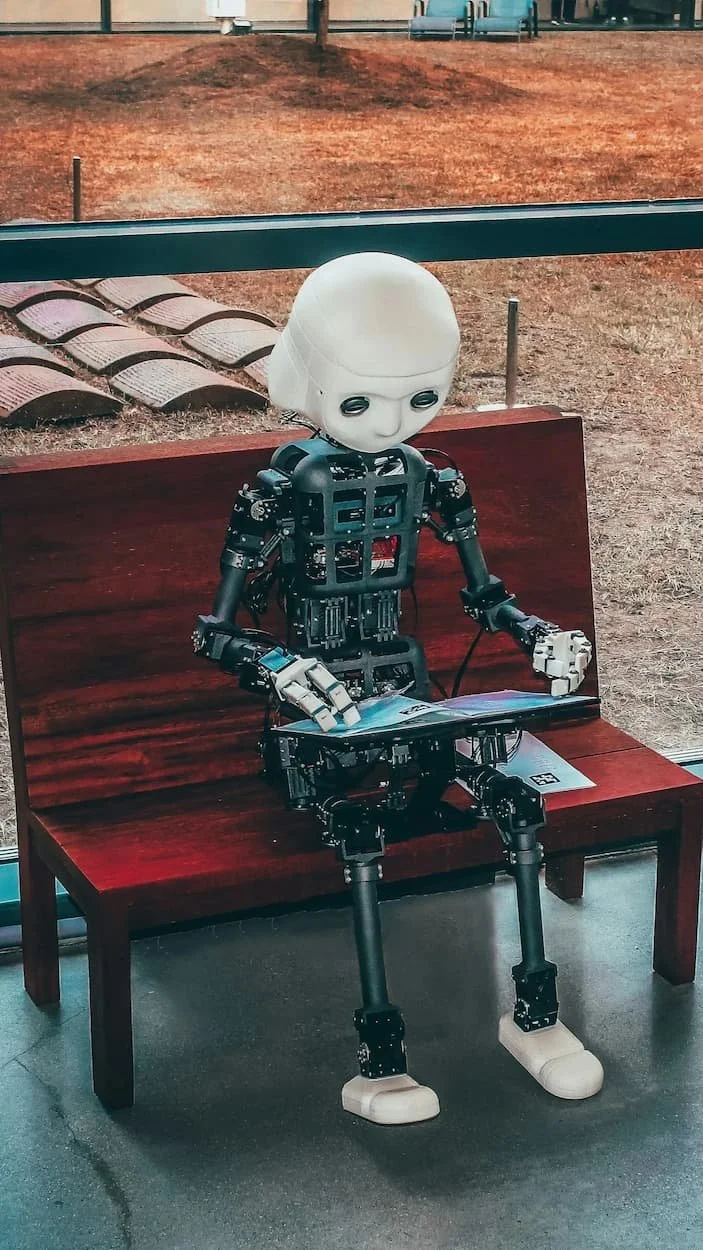 Right level of AI - an AI robot sitting and reading on a bench
