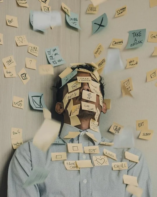 Person covered in sticky notes, representing administrative overload