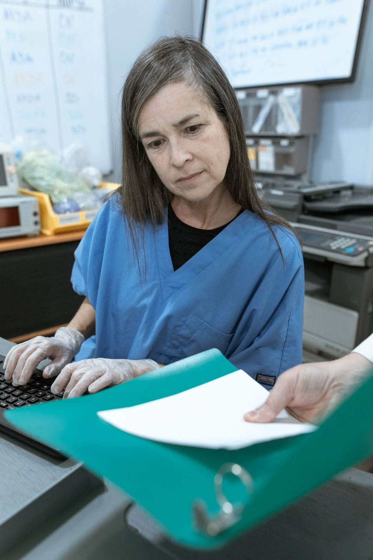 Healthcare professional working at a desk in a clinical environment