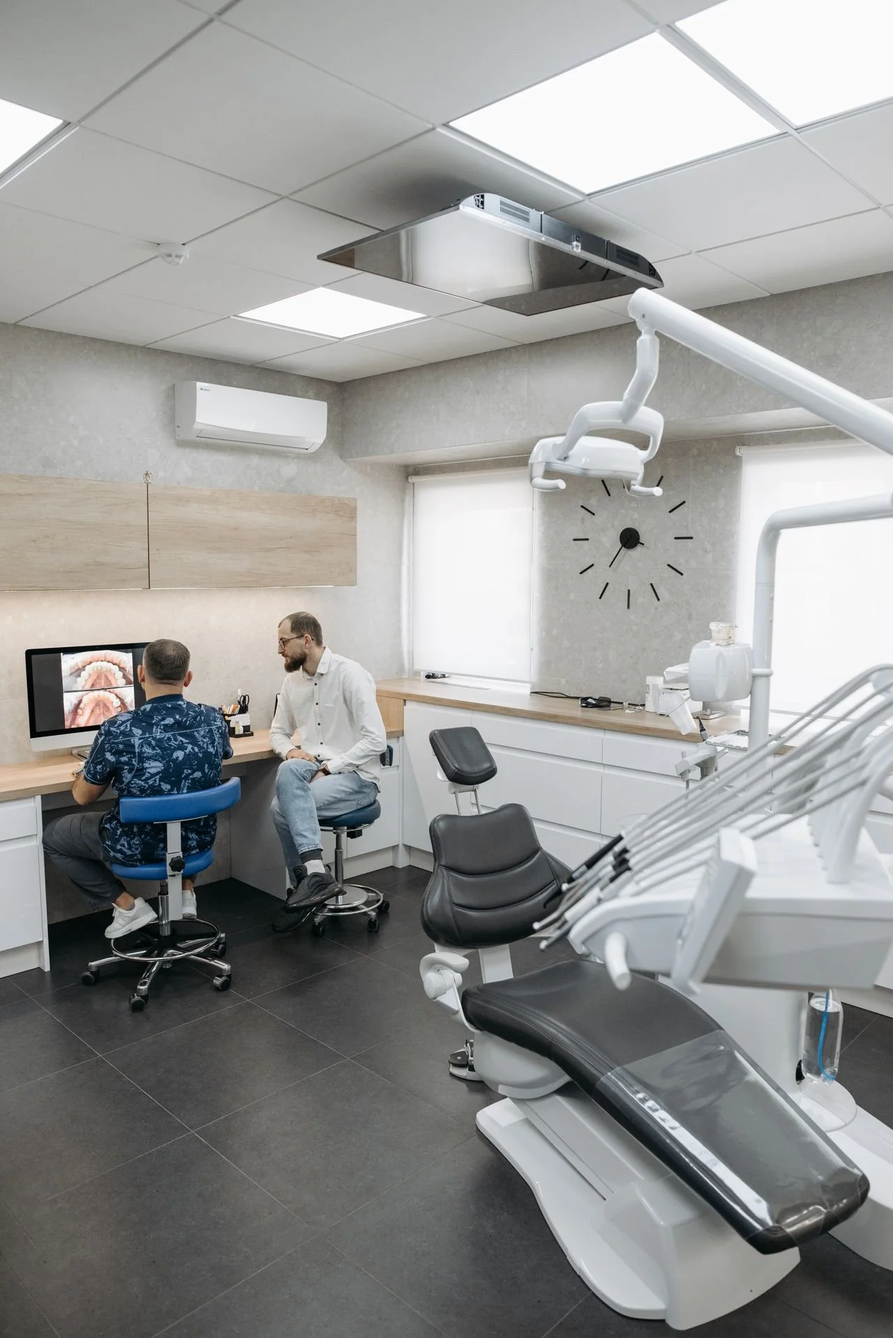 Dental professionals reviewing information together at a computer in a dental operatory
