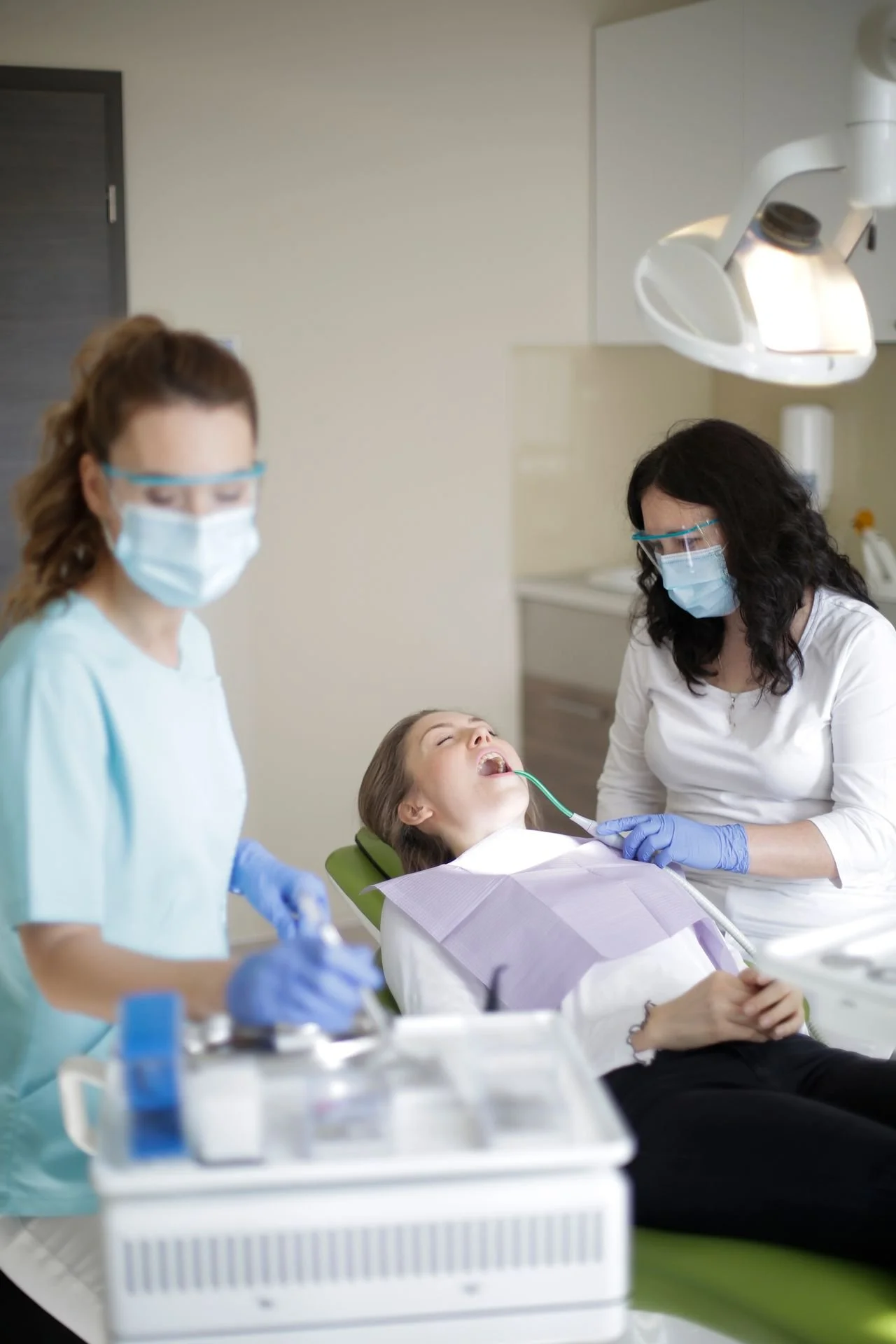 Dental professionals providing treatment to a patient in a dental operatory
