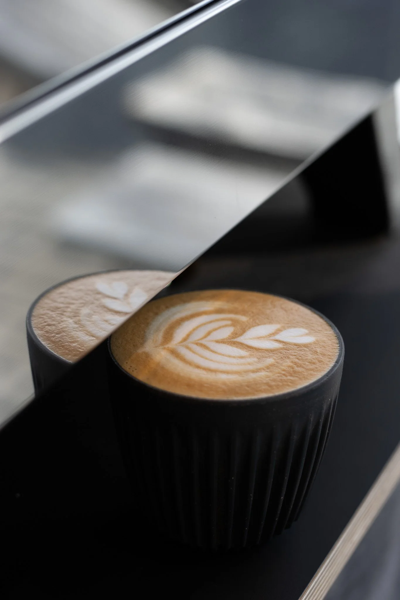 Close-up of a black coffee cup with latte art in a coffee machine. The Scandinavian Coffee Pod.