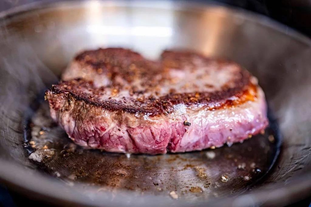 Steak sizzling in frying pan at The Russell Arms.jpeg