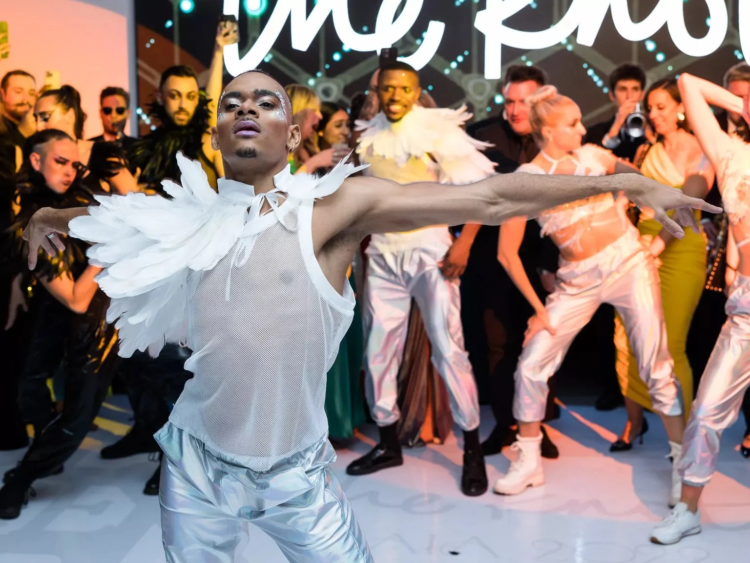 Dancer wearing a white mesh top and silver pants on the dance floor at The Knot Gala