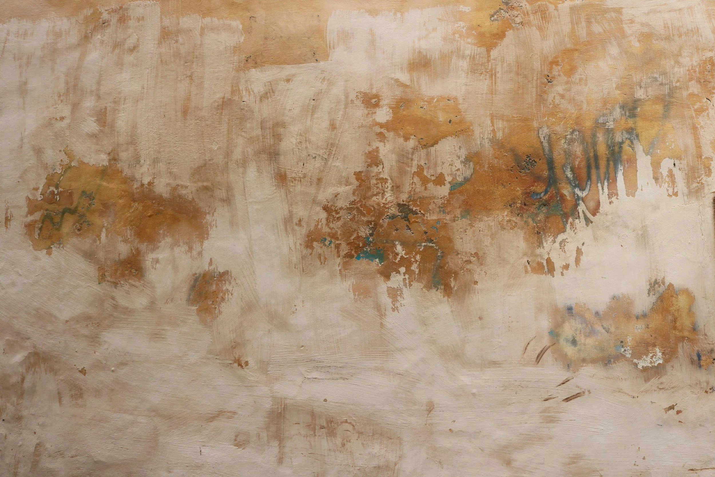 Abstract textured wall with earthy tones, patches of brown, ochre, and hints of blue and teal.