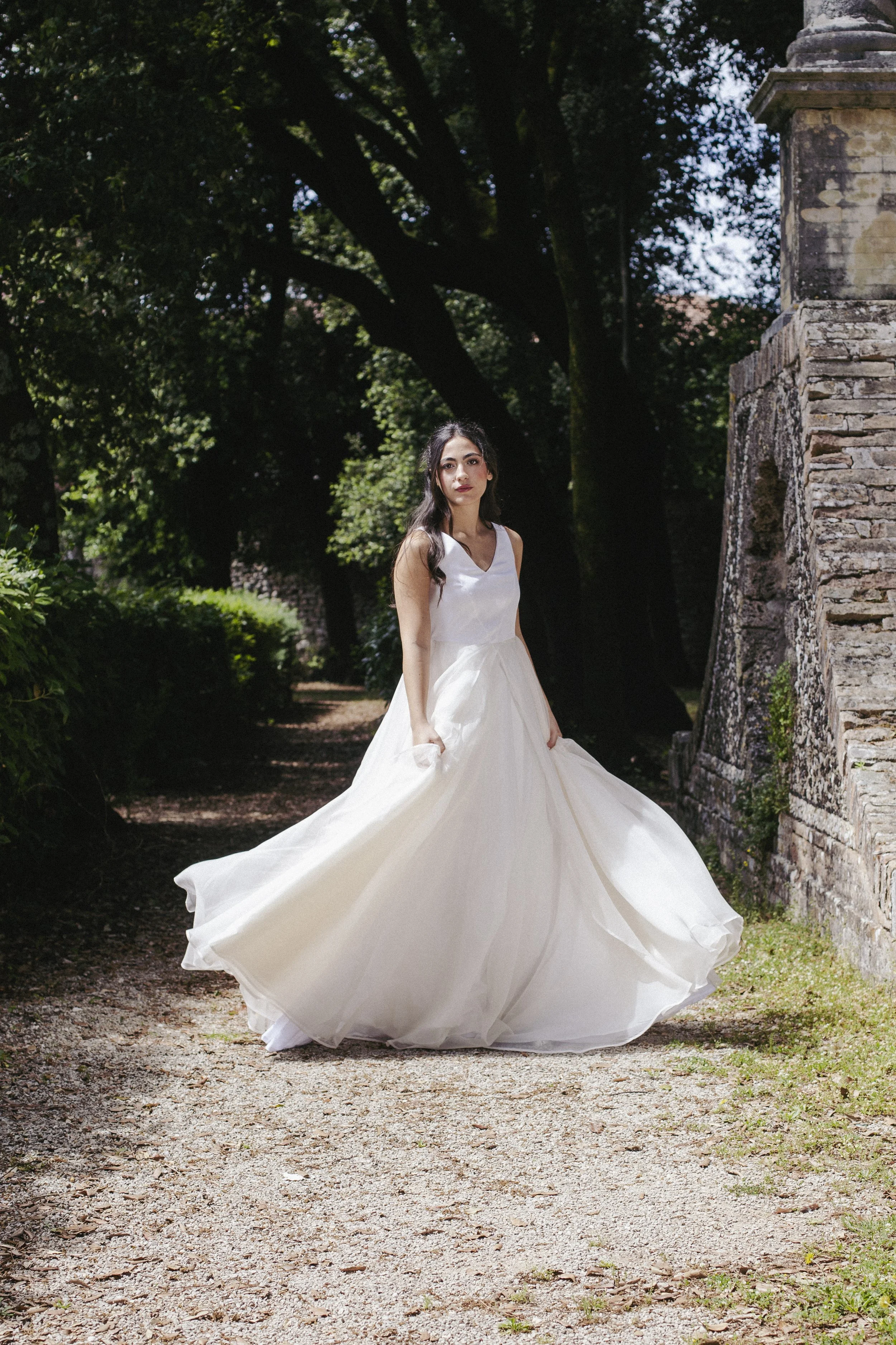 Primula
Starting from €2,300
A sculptural ball gown bridal dress featuring a structured silk drape bodice with a deep keyhole back, paired with a voluminous skirt in 100% silk organza and taffeta. The generous, flowing silhouette moves beautifully wi