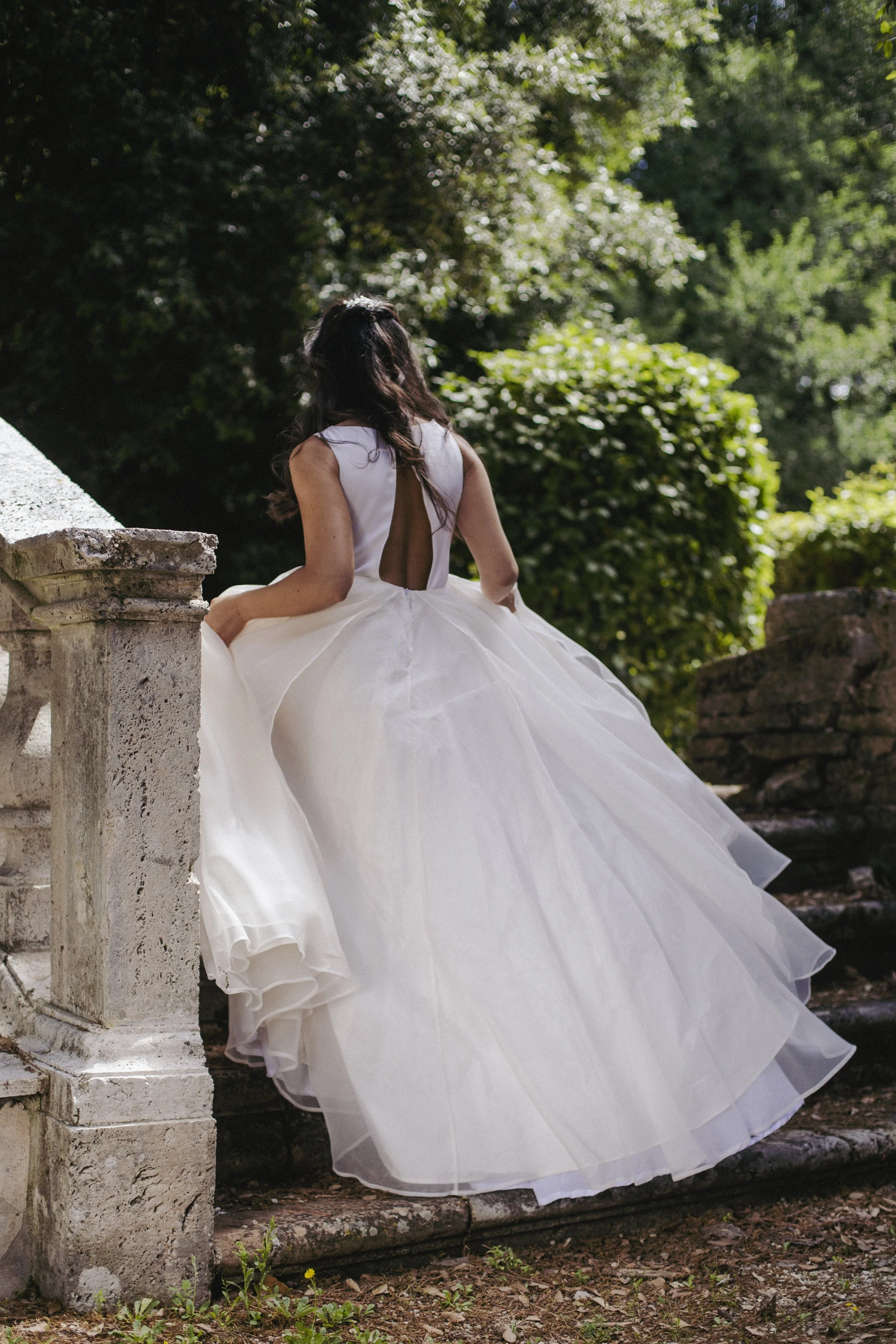 Primula
Starting from €2,300
A sculptural ball gown bridal dress featuring a structured silk drape bodice with a deep keyhole back, paired with a voluminous skirt in 100% silk organza and taffeta. The generous, flowing silhouette moves beautifully wi