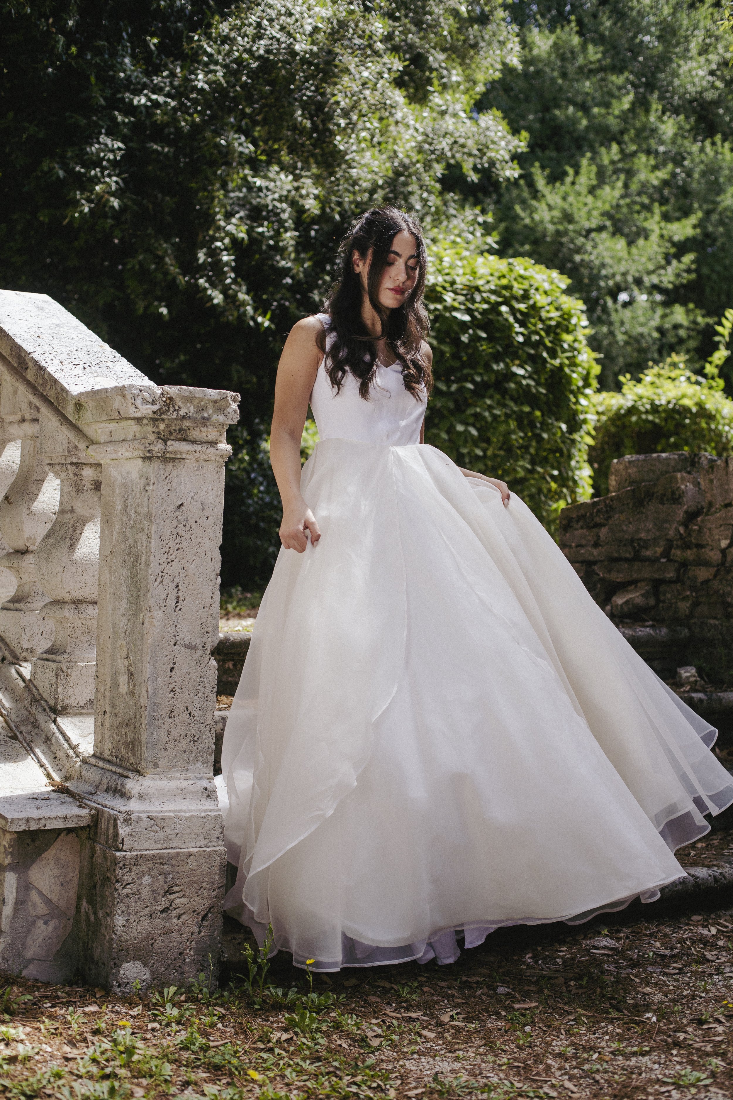 Primula
Starting from €2,300
A sculptural ball gown bridal dress featuring a structured silk drape bodice with a deep keyhole back, paired with a voluminous skirt in 100% silk organza and taffeta. The generous, flowing silhouette moves beautifully wi