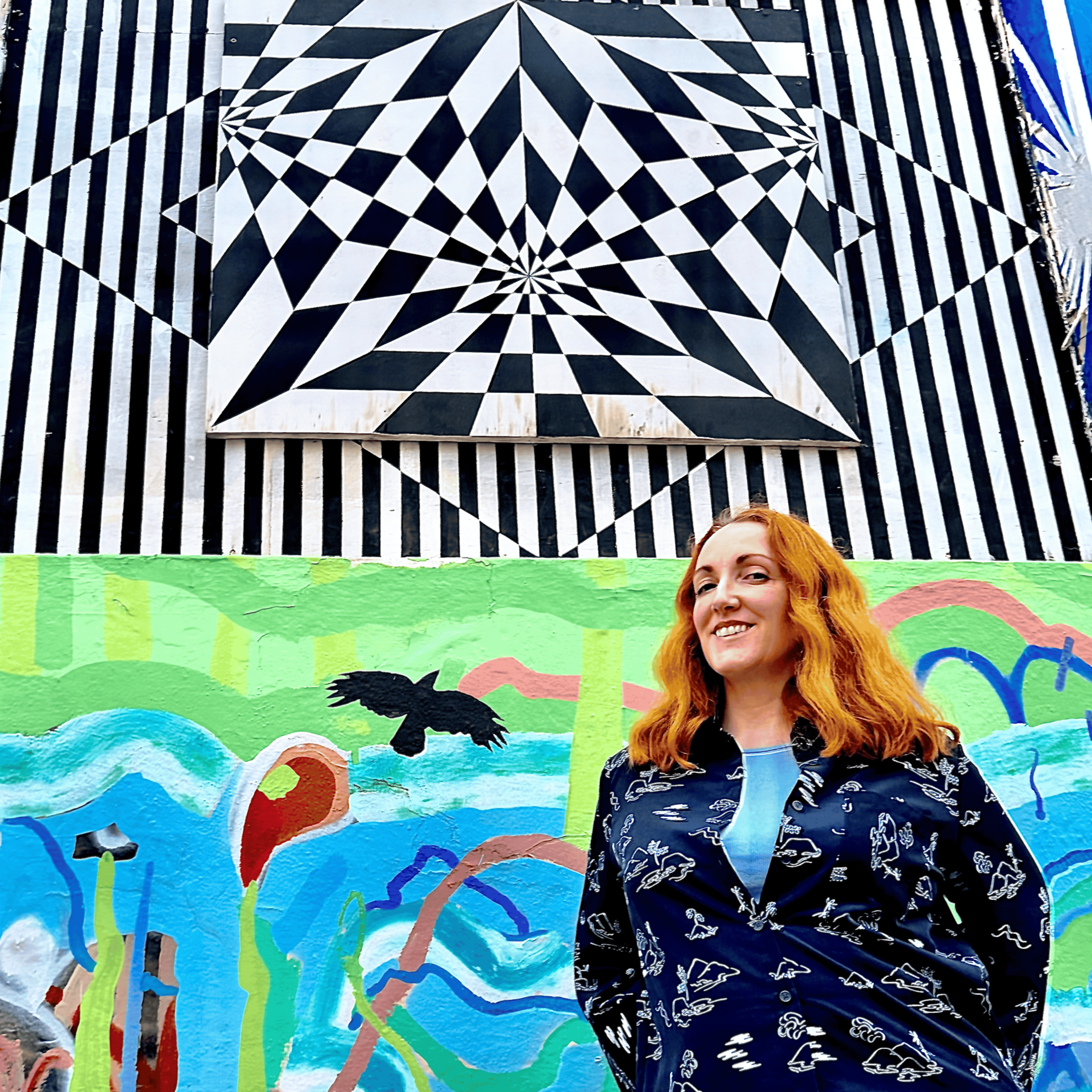Carrie stands in front of bright mural in St Leonards East Sussex