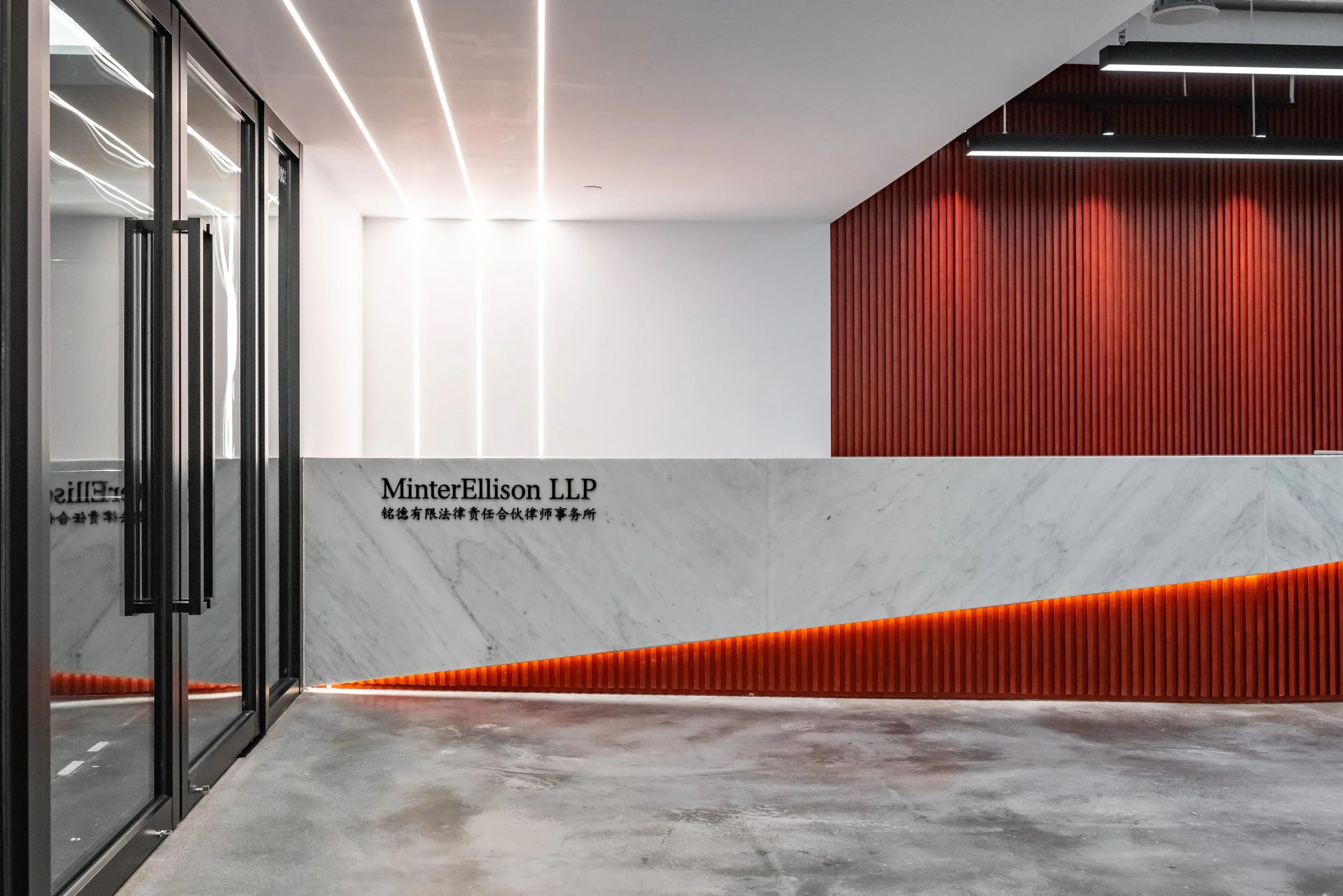 Commercial interior design and design and build at Minterellison LLP Wan Chai, Hong Kong featuring a close up shot of reception area with polished concrete flooring.