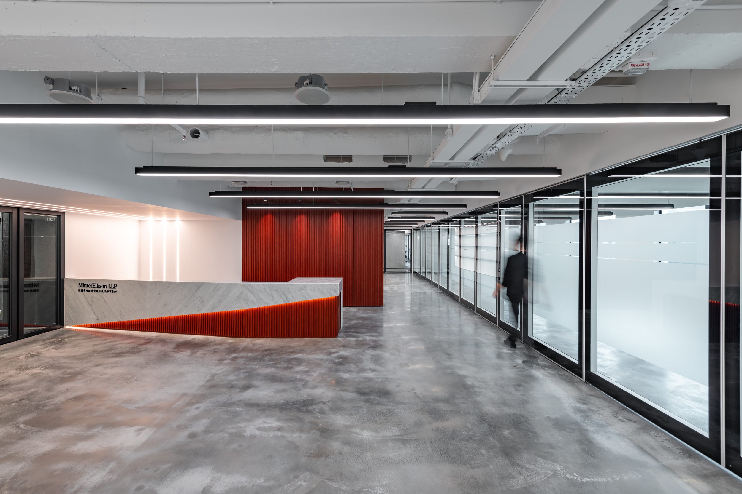 Commercial architecture and interior design at Minterellison LLP Wan Chai Hong Kong featuring industrial reception area with polished concrete flooring.