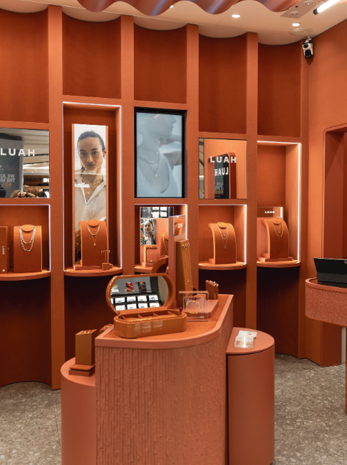 Retail fixture design for LUAH, Hong Kong, featuring illuminated terracotta shelving, jewellery stands and integrated campaign imagery.