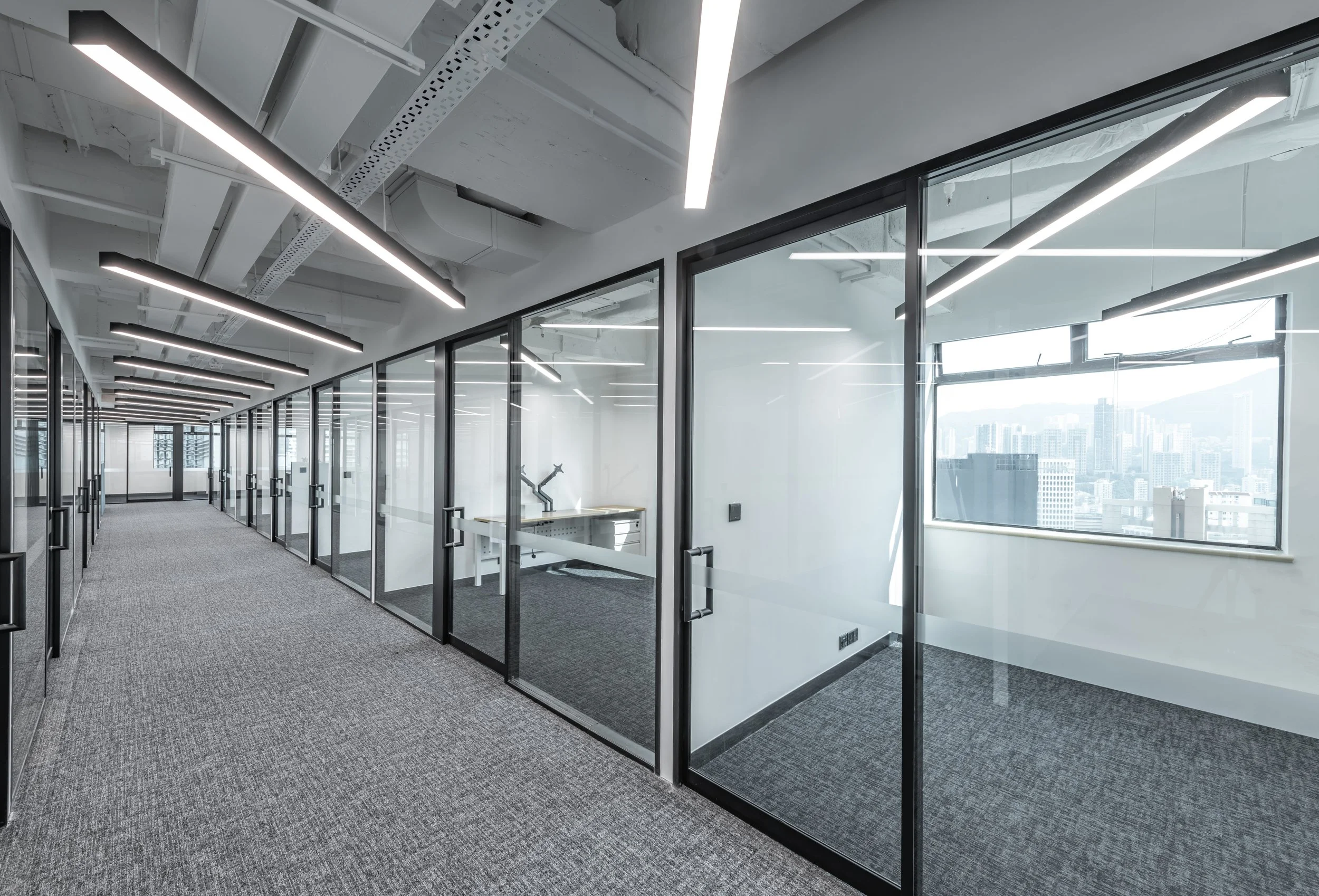 Commercial interior design and build at Minterellison LLP, Hong Kong displaying clean commercial office space with floor to ceiling glass panel and other industrial architectural elements.