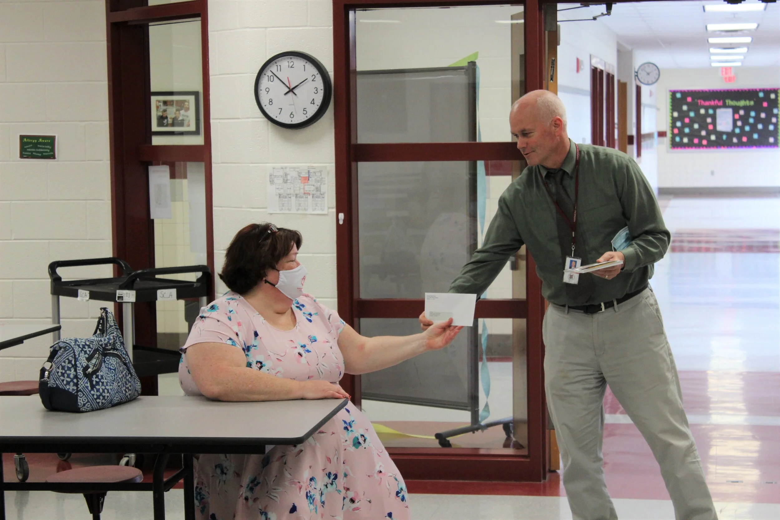 Eric Stewart, principal of Harmony Middle School, giving Pastor Krista Vingelis a check for the Western Loudoun Food Pantry.