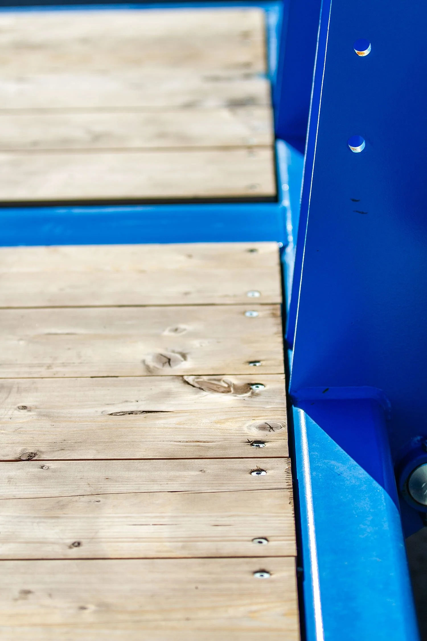 Blick auf eine Holzplattform mit blauer Metallrahmen an der Seite.