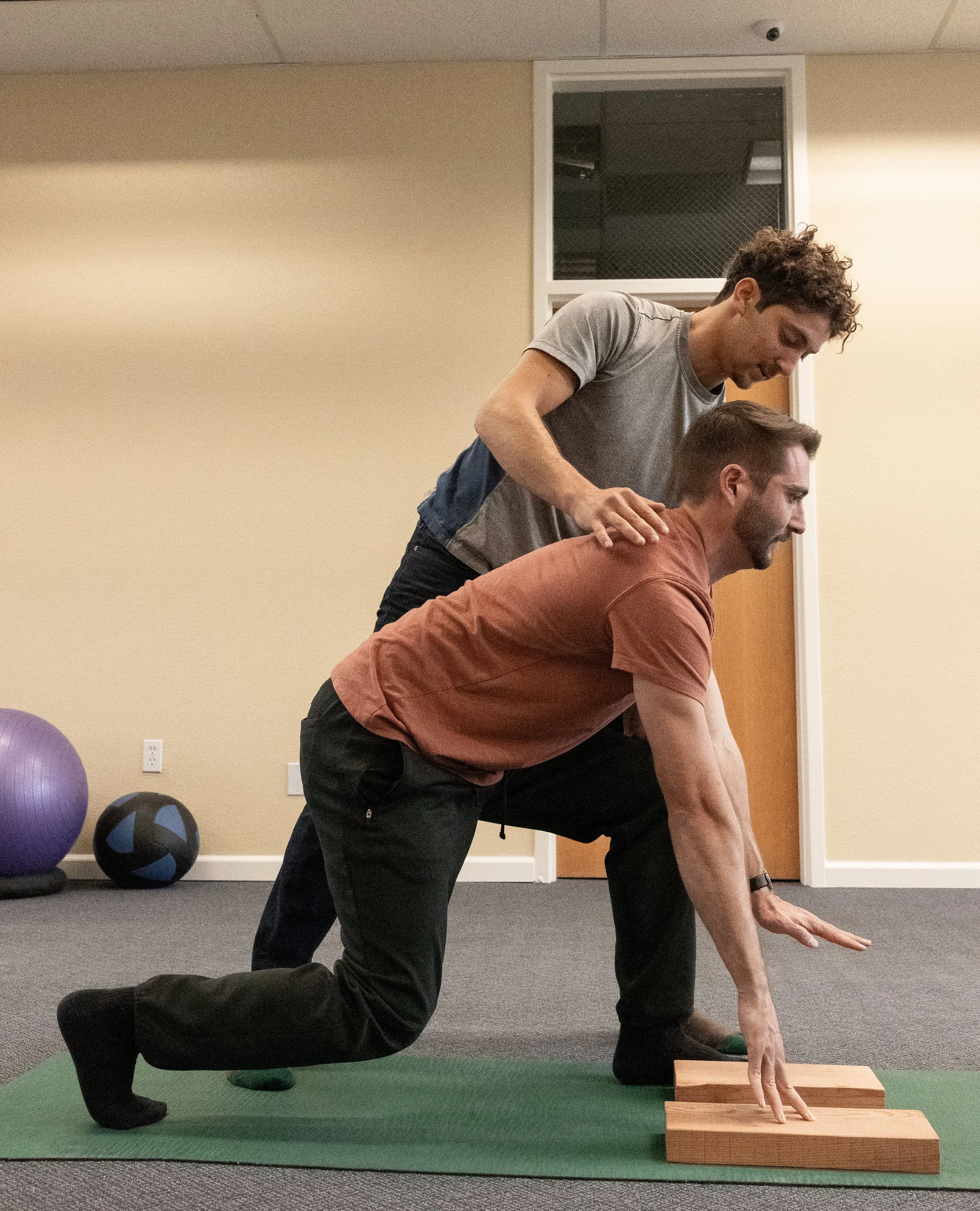 Post-surgery fitness training: Trainer spotting a client during a controlled leg exercise as part of recovery after surgery.