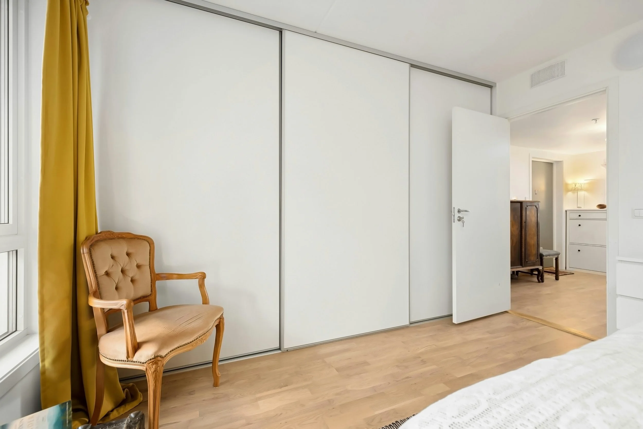 White timber sliding door wardrobe with matt silver frame.