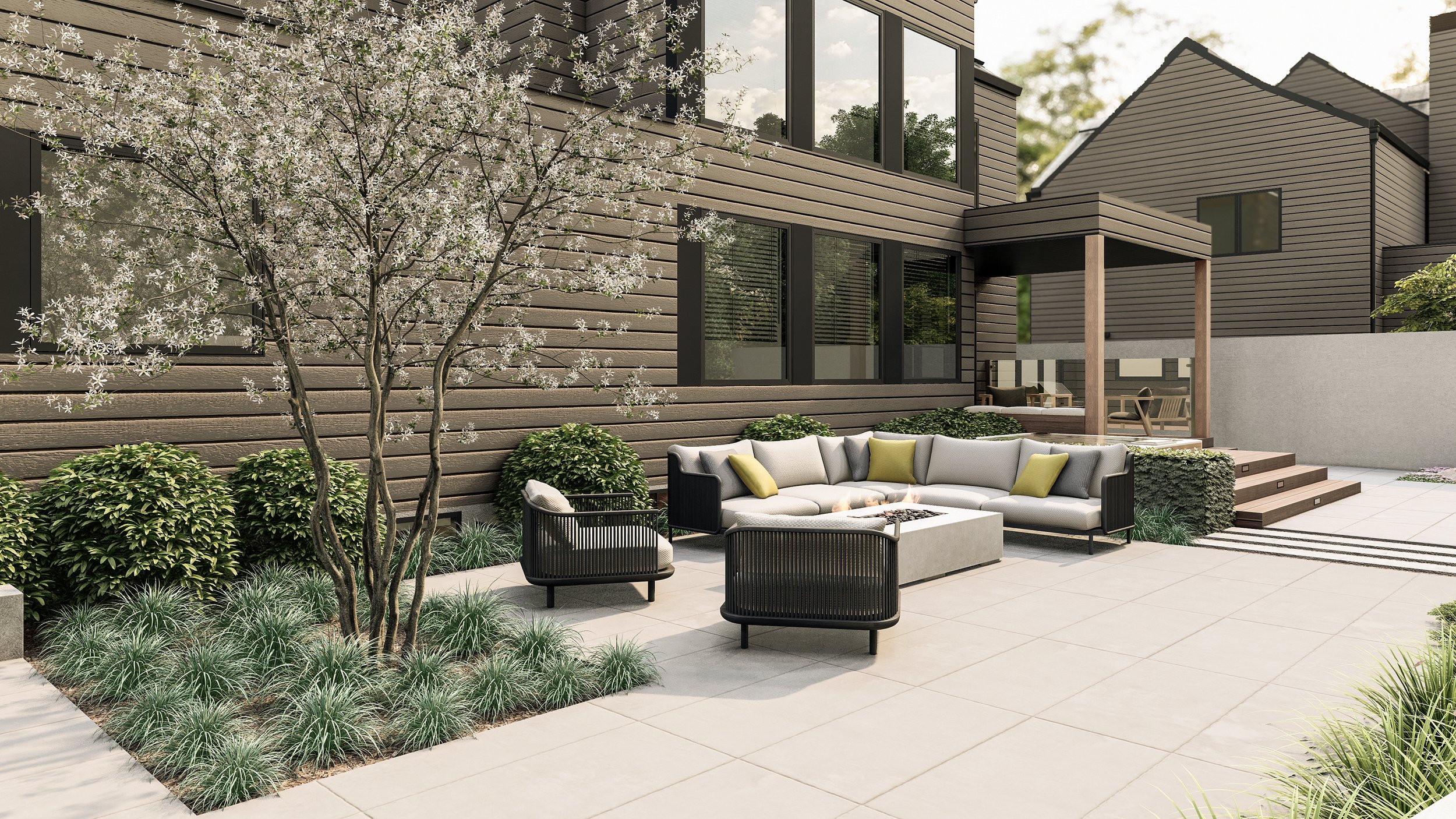 Modern backyard with patio seating, a dining table, and greenery including a blooming tree and various plants, surrounded by a light-colored fence.