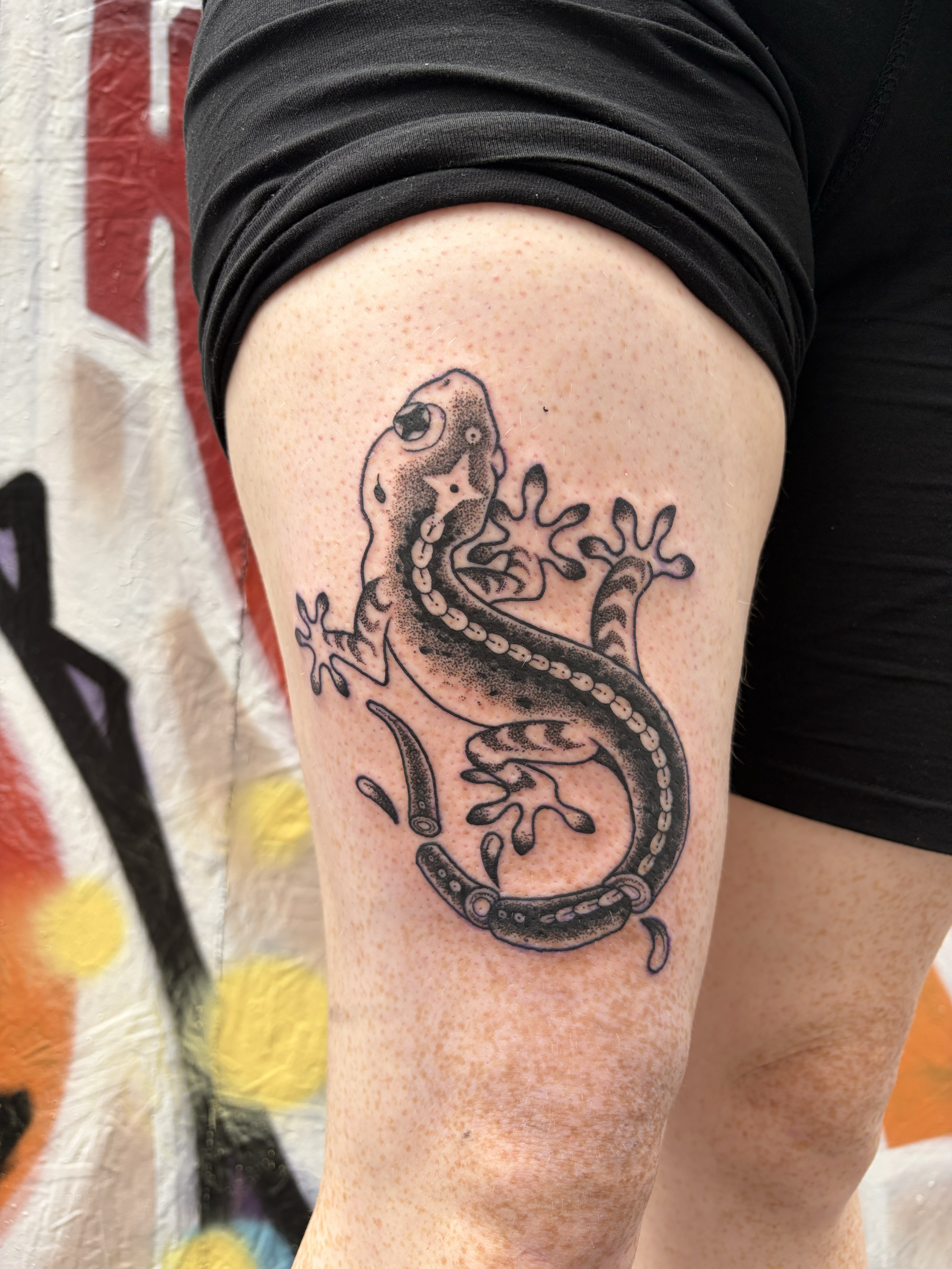 dotwork lizard gecko tattoo with tail cut into pieces climbing up the leg stippling blackwork bold 