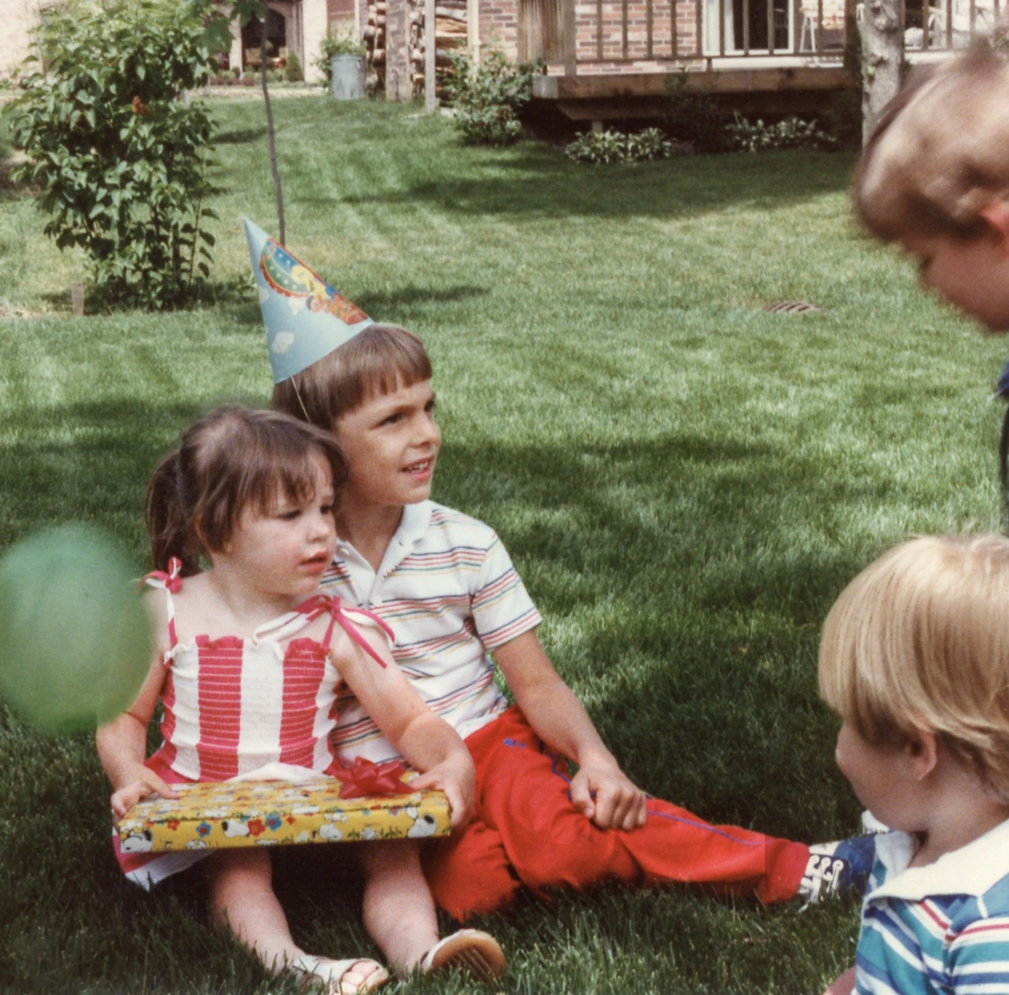 Kelly is opening her birthday gifts with her cousin David by her side.